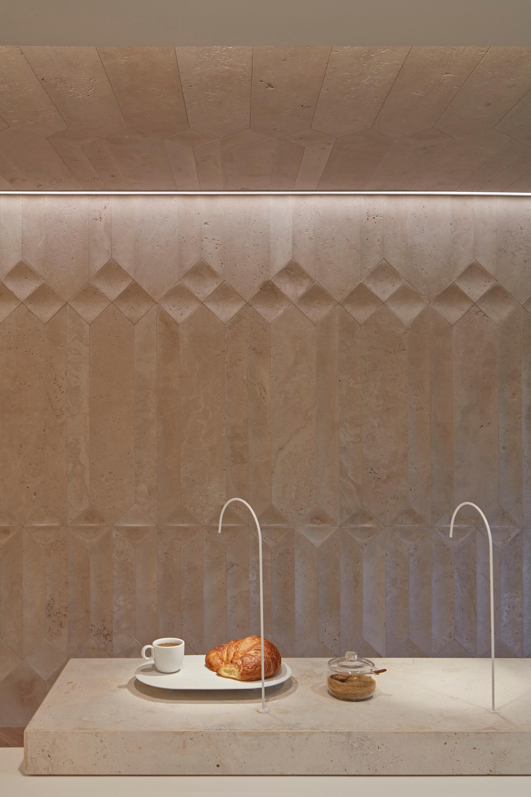 Custom designed travertine walls create unique shadows inside a coffee shop.