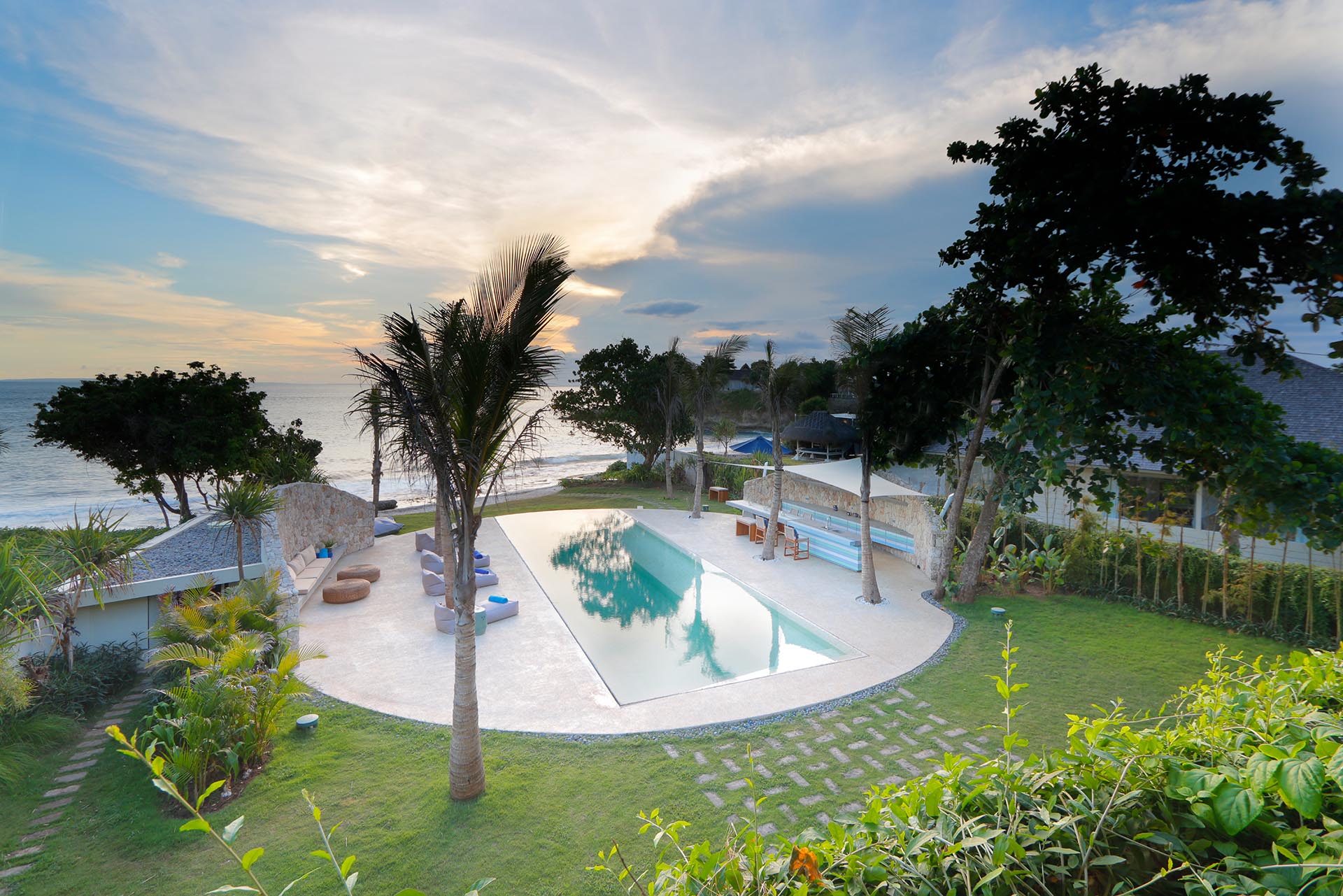 A modern beach house with a swimming pool that includes a round patio.