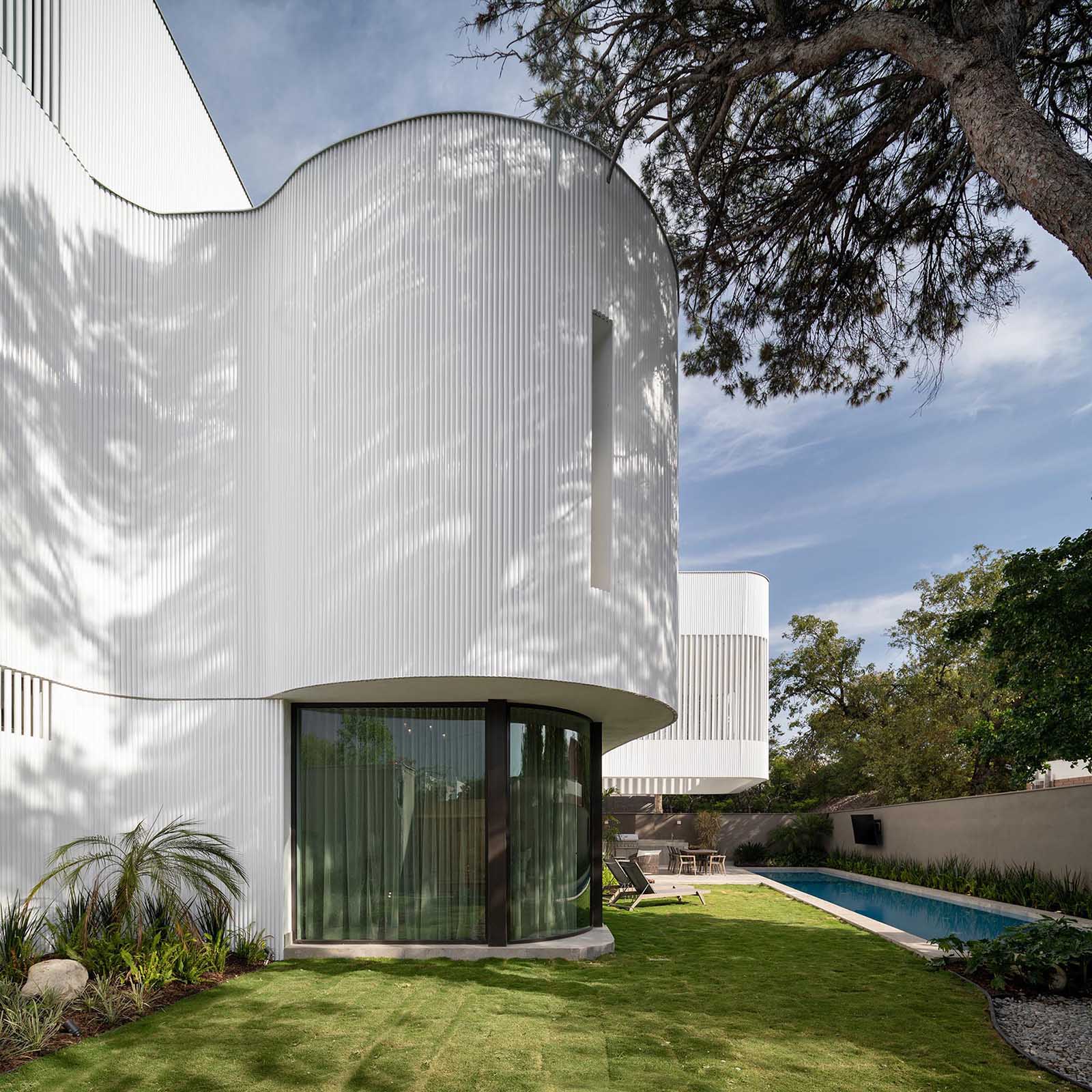 The metal pipes create a screen on the exterior of this modern house, and serve as a rainscreen for the solid walls, act as privacy and shading for selected windows