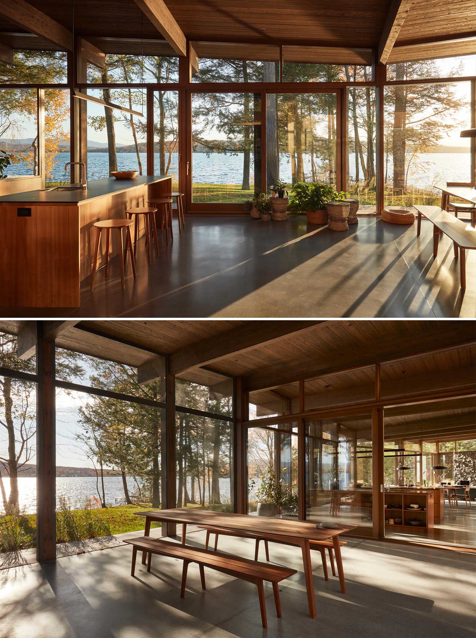 This modern kitchen with two islands also includes flat paneled walnut cabinetry, open shelving, black Fenix NTM countertops, and concrete flooring.