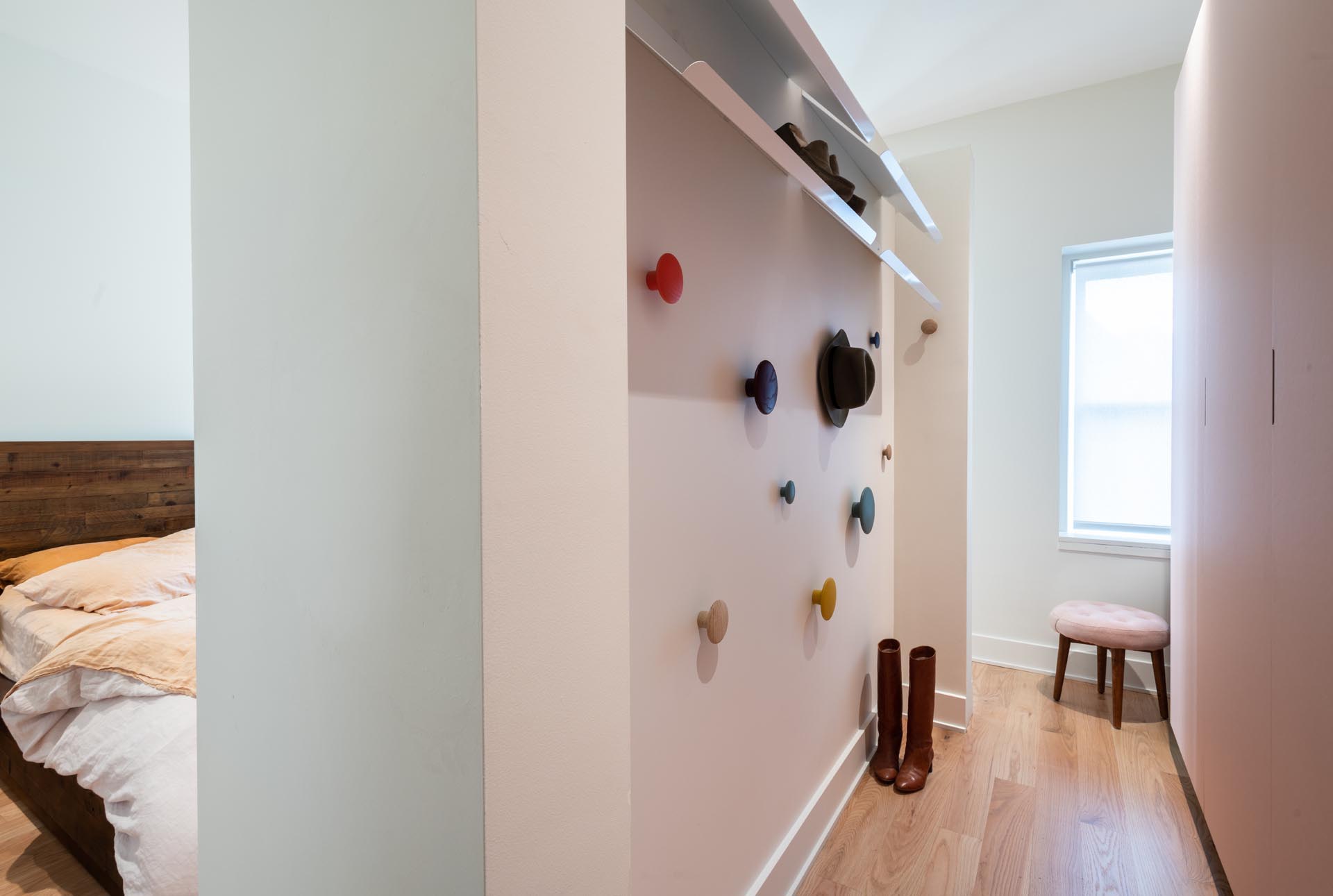 The vanity and wardrobe space of this modern bedroom boast fun hanging elements and colorful walls to create a playful space.