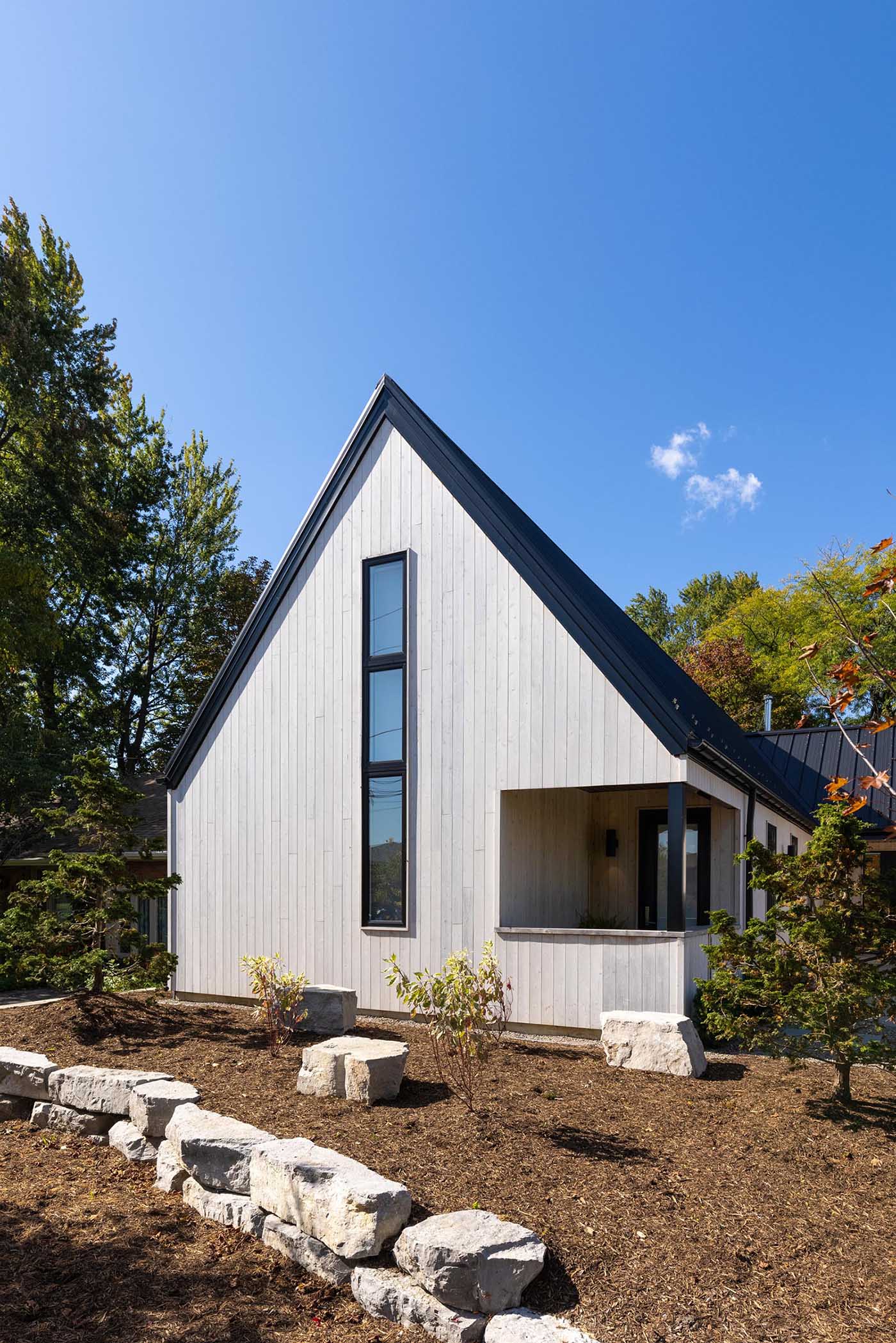 The exterior finishes of this Scandinavian inspired home includes vertical white cedar siding and standing seam metal roofs.