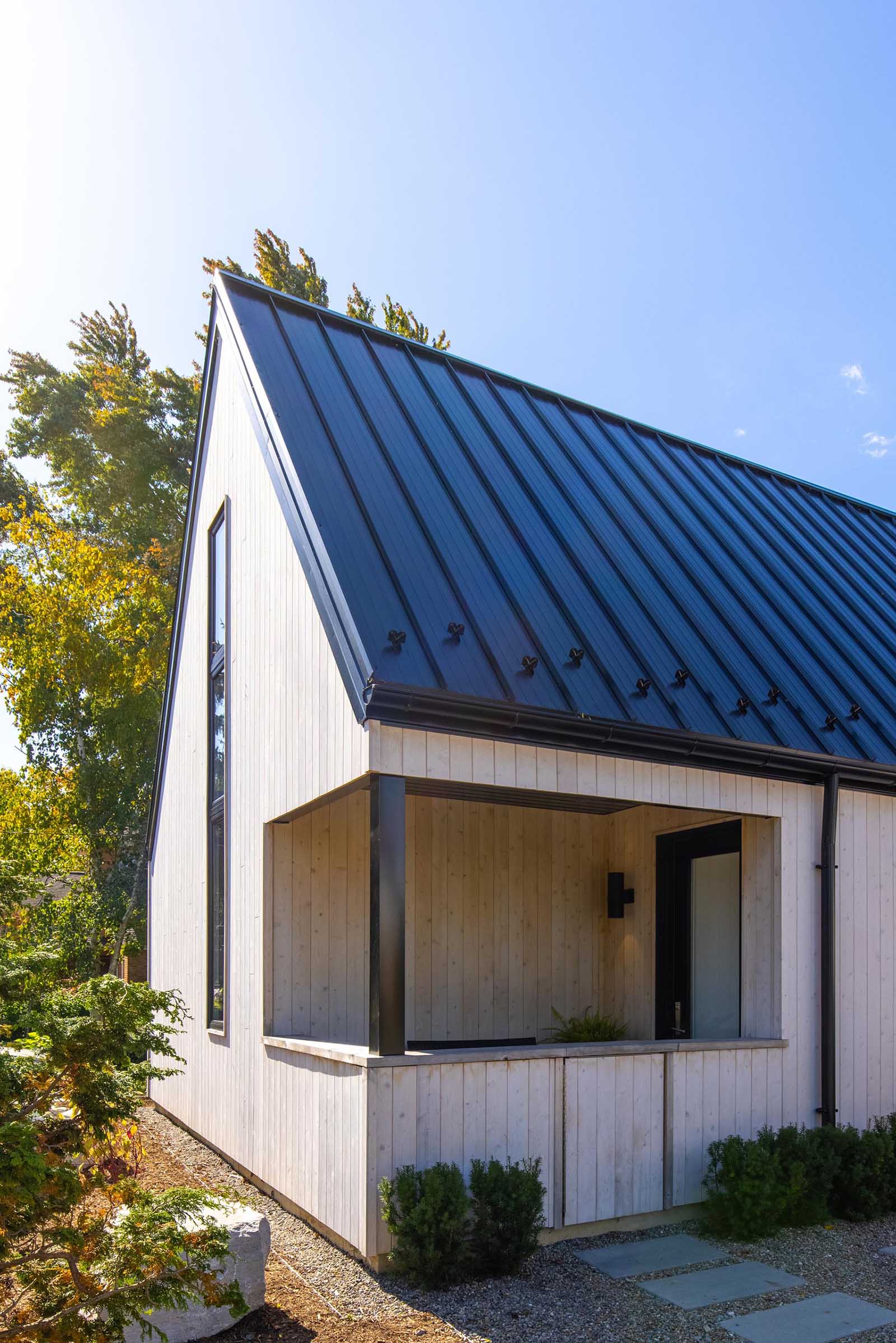 The exterior finishes of this Scandinavian inspired home includes vertical white cedar siding and standing seam metal roofs.