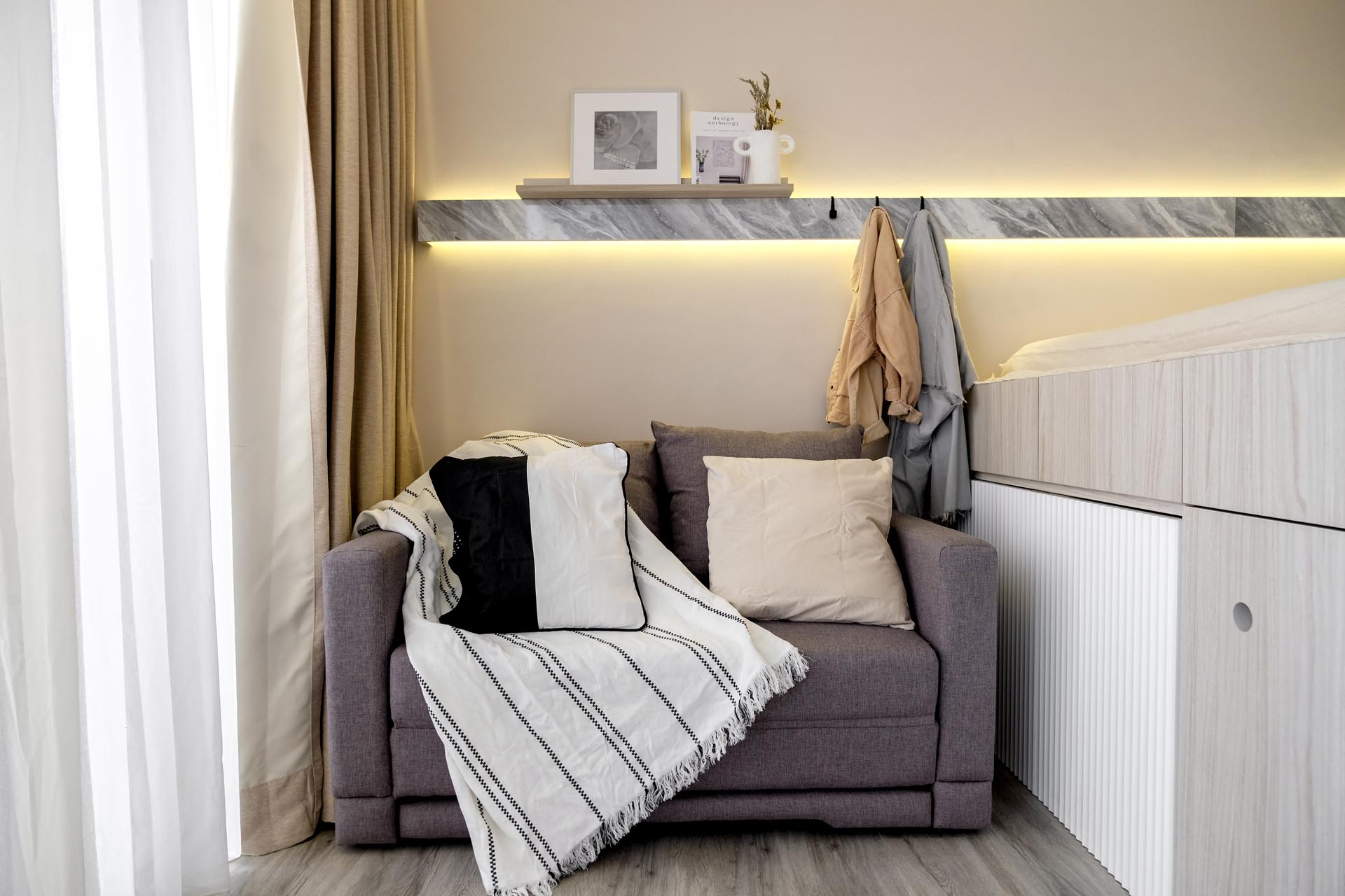At the end of a platform bed is a small two-seater sofa which can transform into a guest bed when needed.