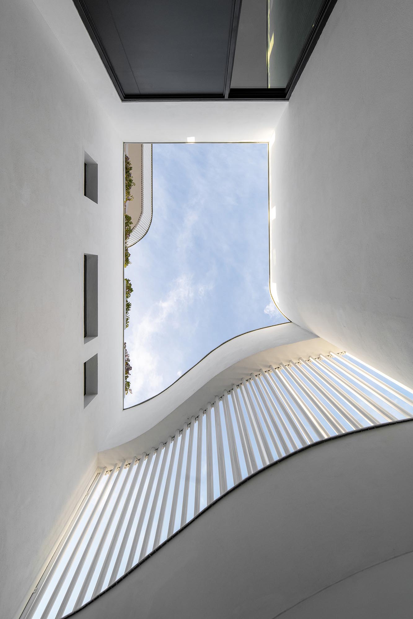 The metal pipes create a screen on the exterior of this modern house, and serve as a rainscreen for the solid walls, act as privacy and shading for selected windows