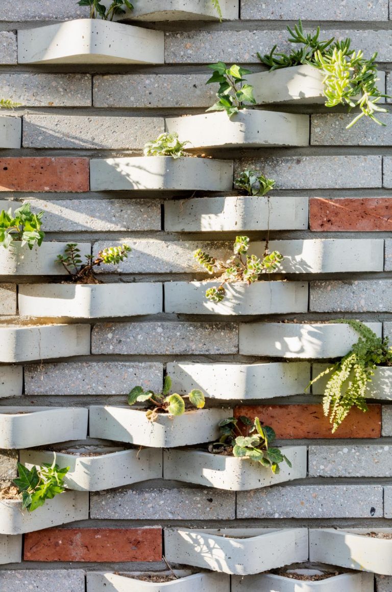 Bricks Designed To Hold Plants Were Used On The Exterior Of This Housing