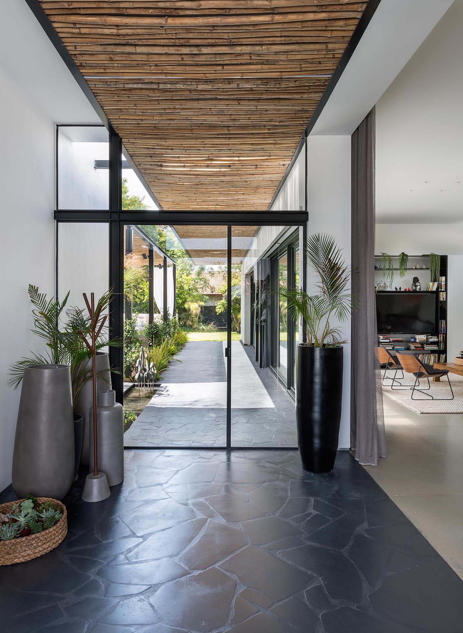 This modern bamboo screens act as a rain cover for the black front door, and flow through to the interior of the home, and then onto the backyard.