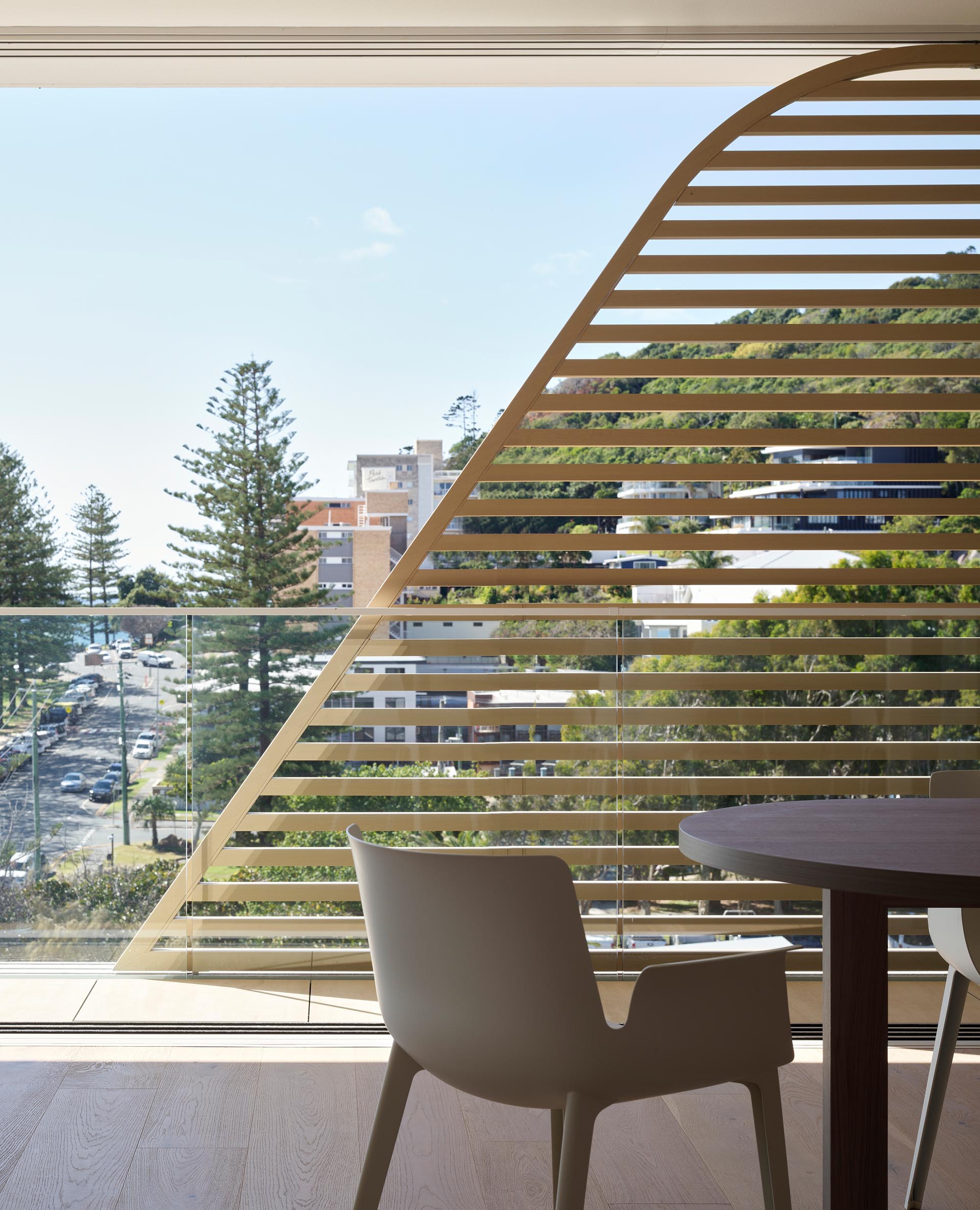 A modern balcony with a wood slat screen.