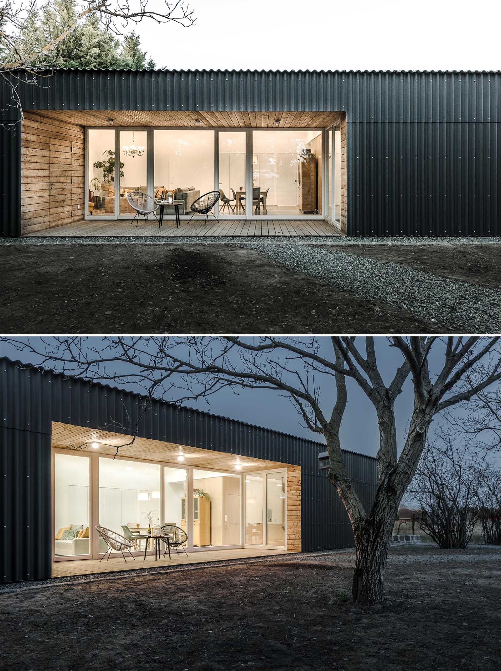 A modern house with corrugated fibre-cement slate siding and alcoves lined with larch wood siding.