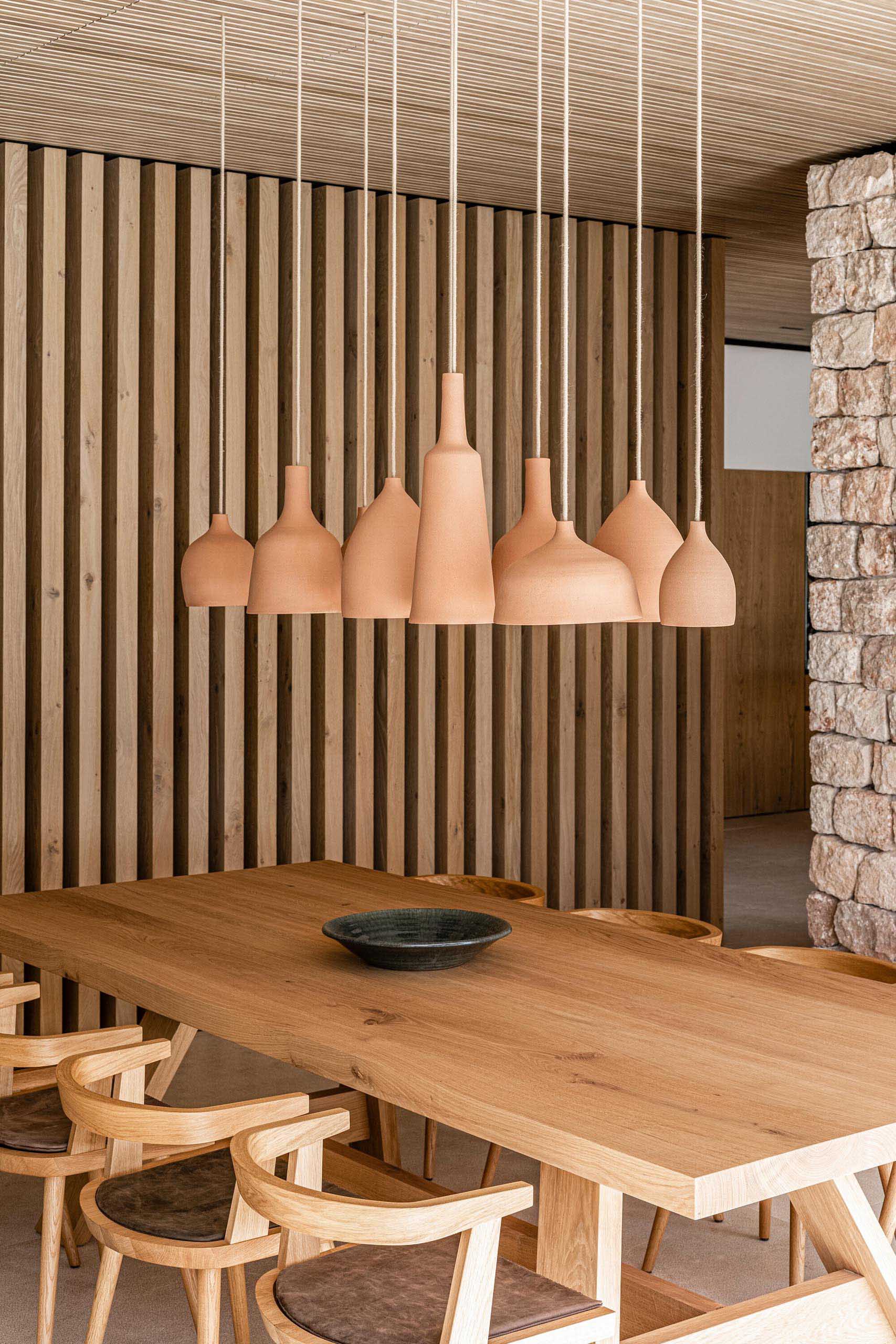A group of handmade ceramic pendant lights create a focal point above the dining table.