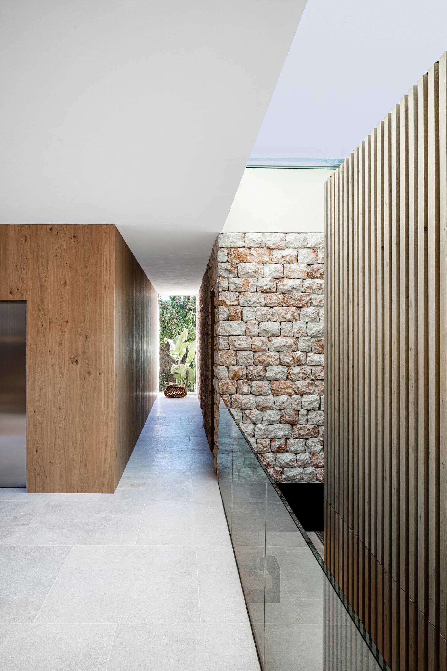A modern hallway showcasing wood, stone, glass, and concrete.