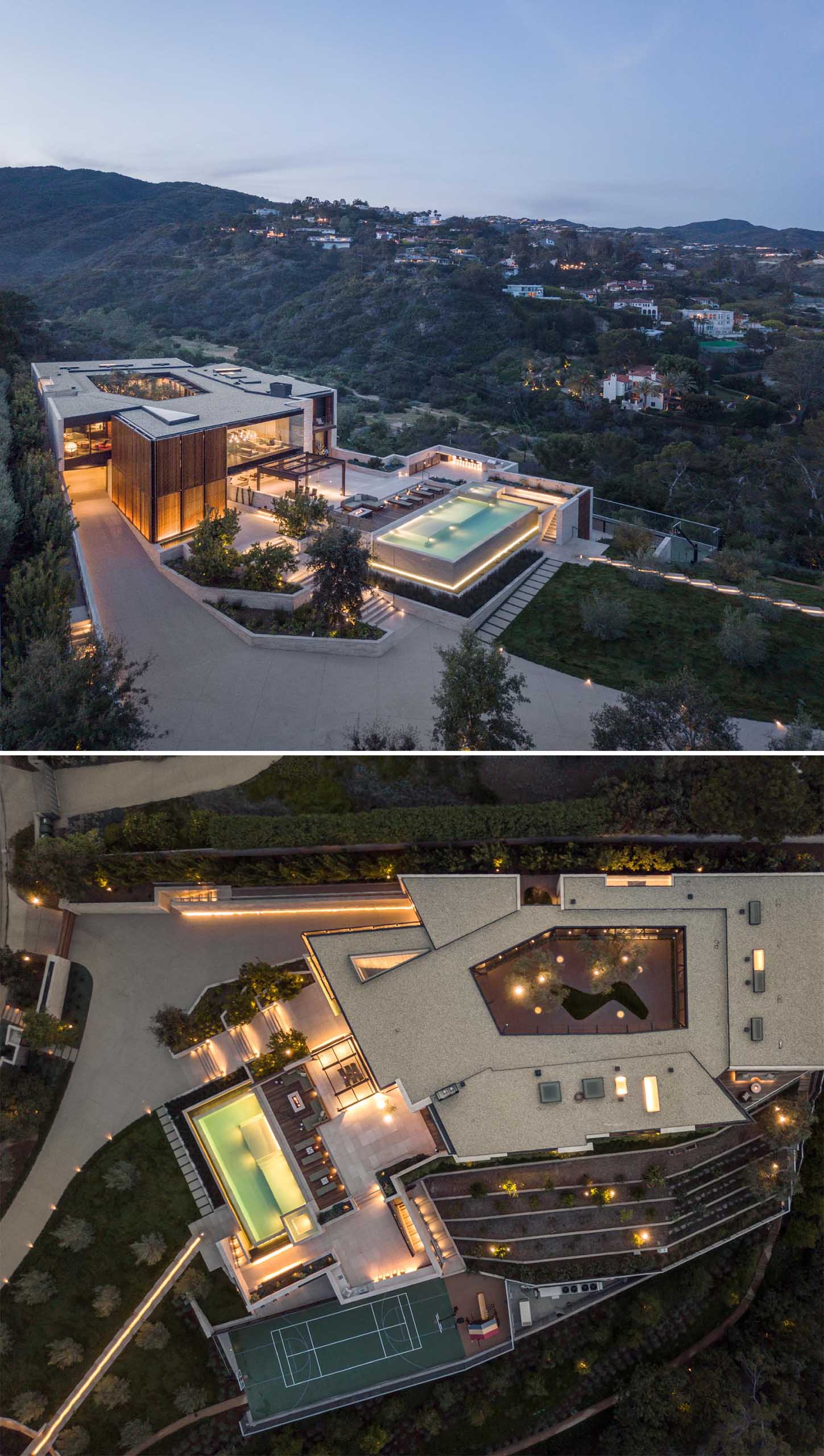 This modern home, which showcases a material palette of limestone, wood, and glass, includes a large terrace that complements the natural contours of the site and features an outdoor dining area, a BBQ area, a swimming pool, and basketball court.