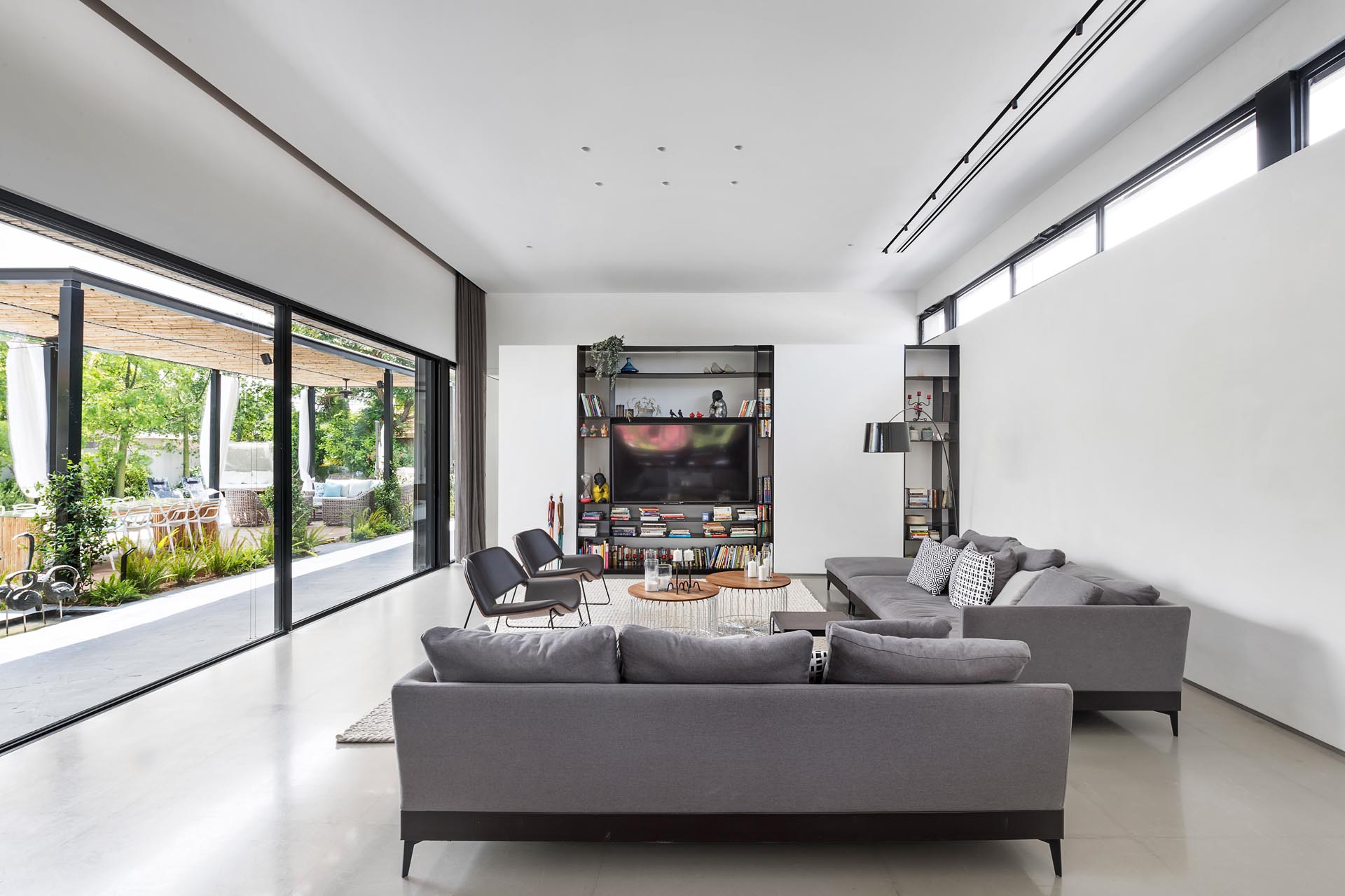 At one end of this modern great room is the living room, that includes a large sliding glass door that opens to the outdoor spaces.