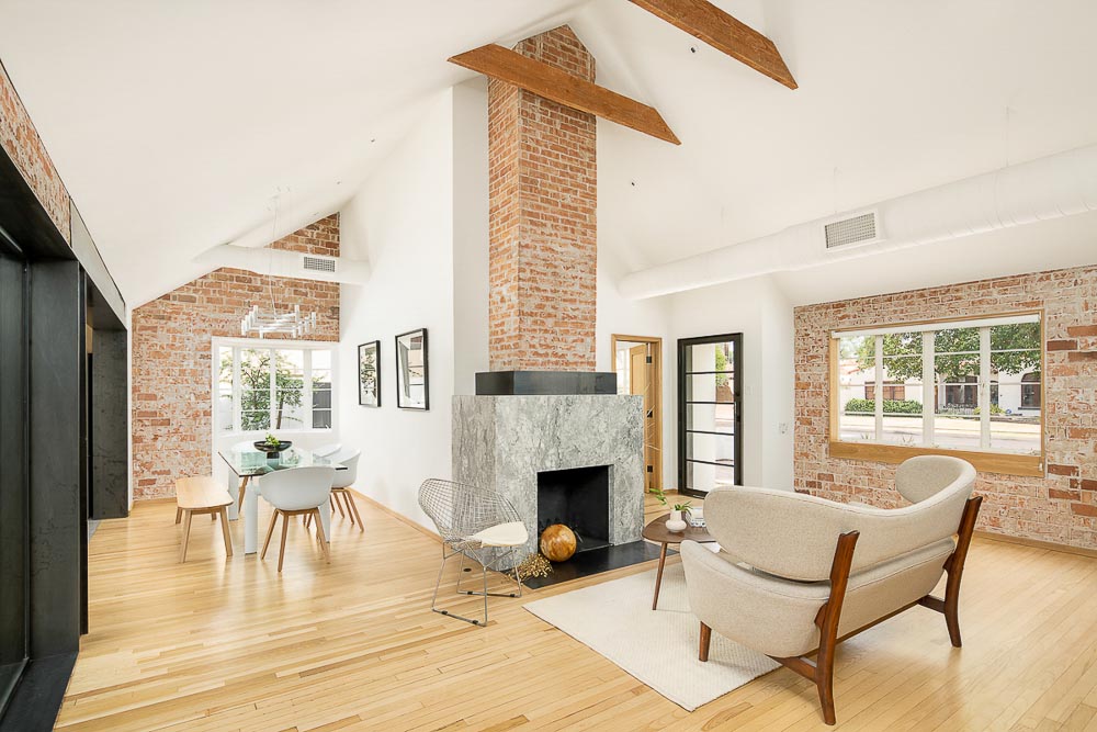 This remodeled home includes vaulted ceilings, original brick, a fireplace, and wood floors.