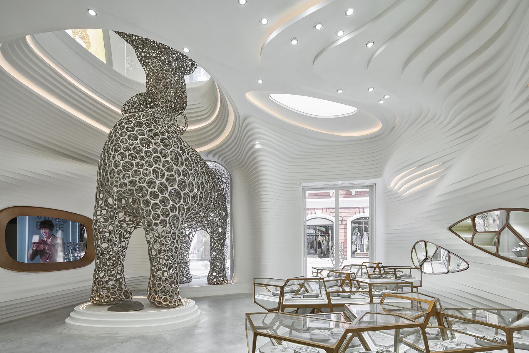 A modern retail store with an eye-catching facade, large sculptures, and a cave-like interior.
