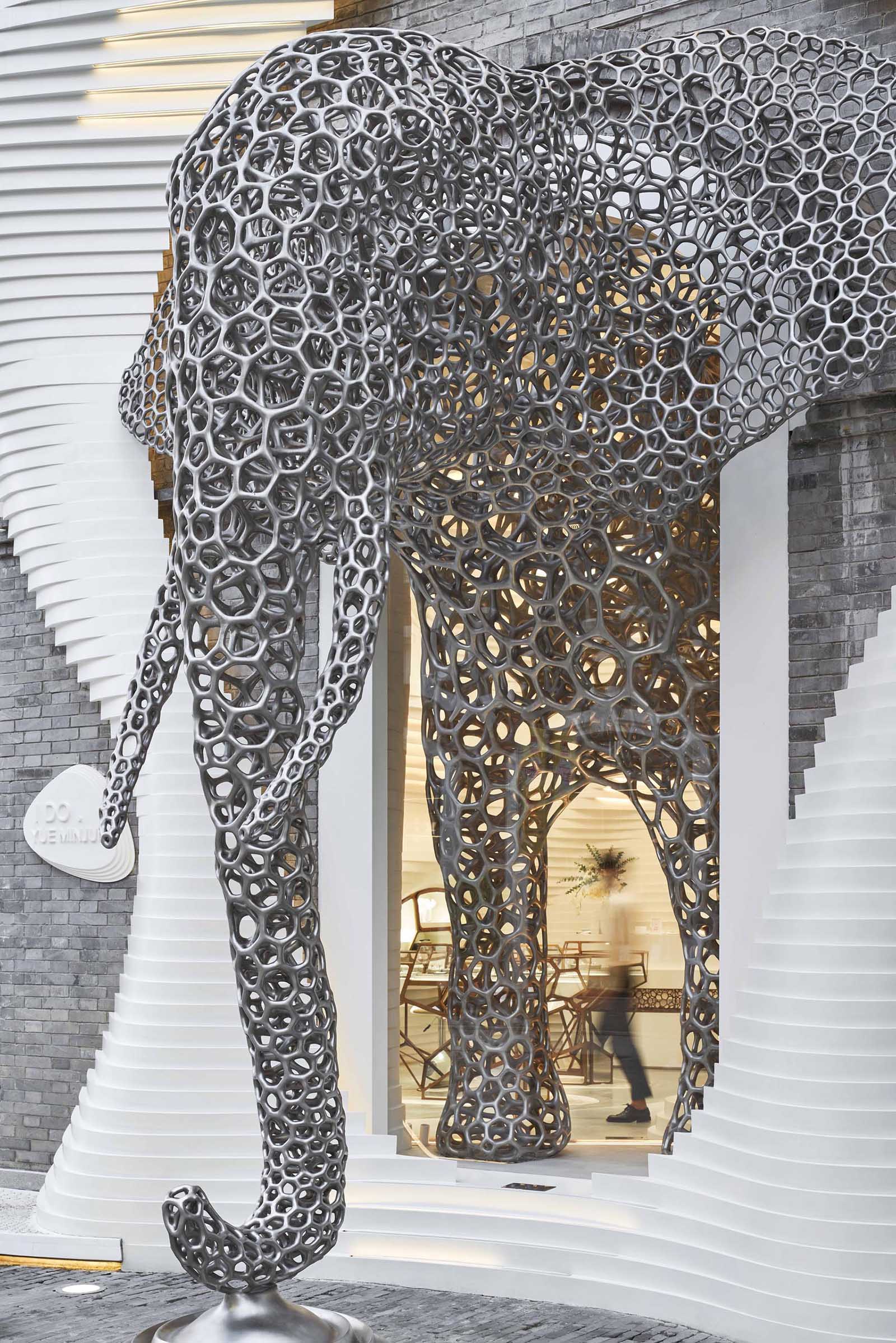 A modern retail store with an eye-catching facade, large sculptures, and a cave-like interior.