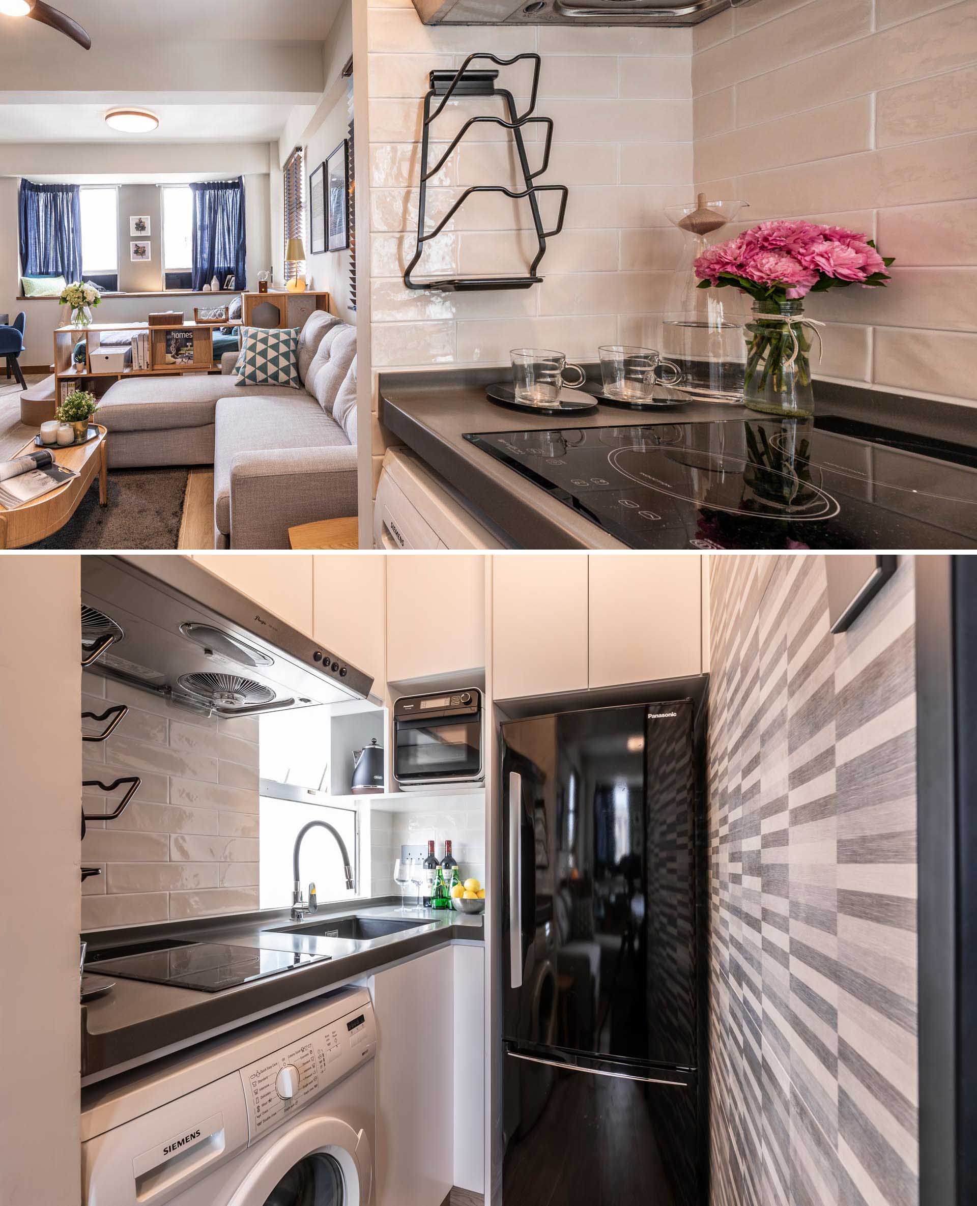 A small apartment with sleek charcoal black painted metal framed glass sliding door that reveals a tiny kitchen, that also includes a washing machine.