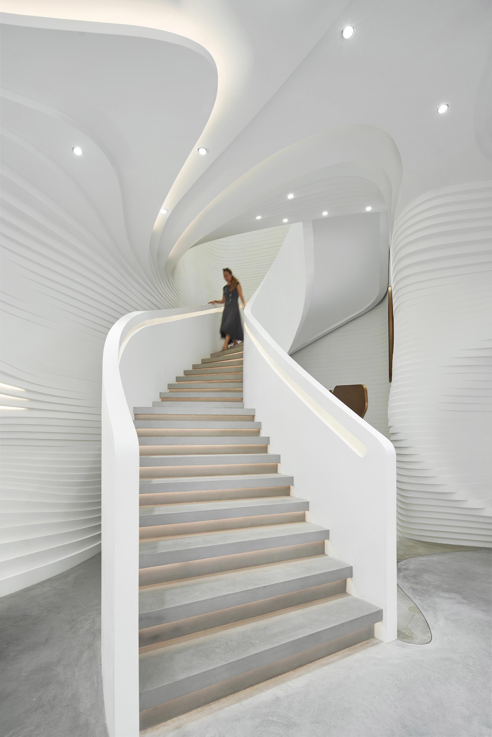 The lighting throughout the space are almost like gems, while the hidden lighting in the ceiling, the stair handrail, and underneath the stair treads, adds a soft glow to the space and highlights the design.