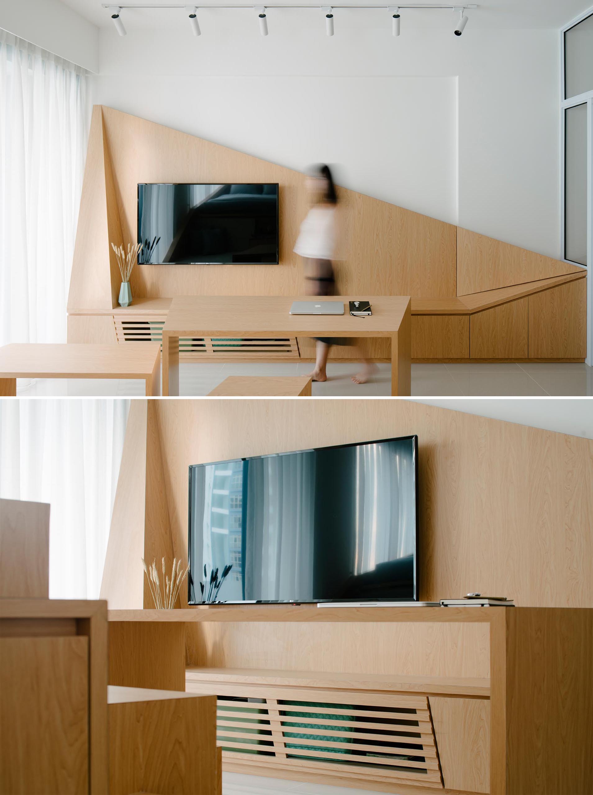 In a small apartment, a custom wood wall provides a backdrop for the television, adds interest with its angular design, and includes additional storage.