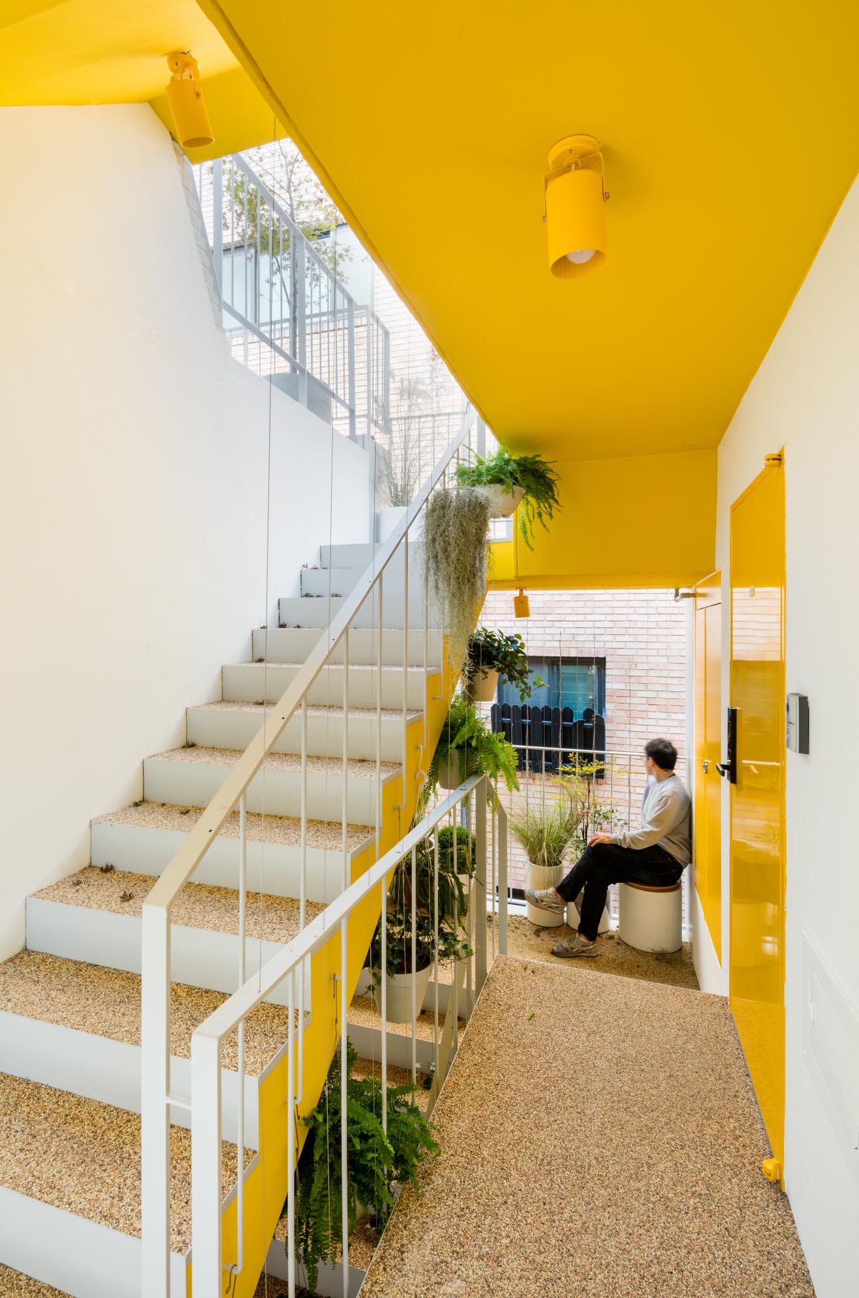 A modern apartment building that has yellow accents in a stairwell.