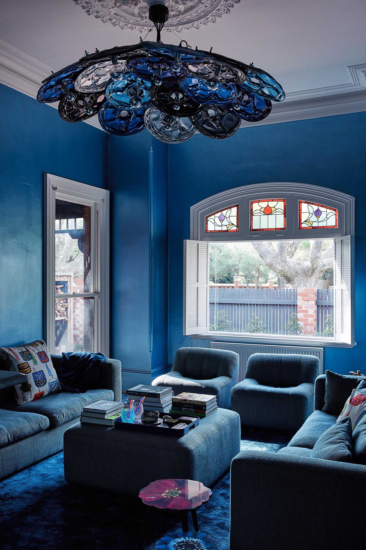 An updated living room in a heritage house has a bold blue color palette.