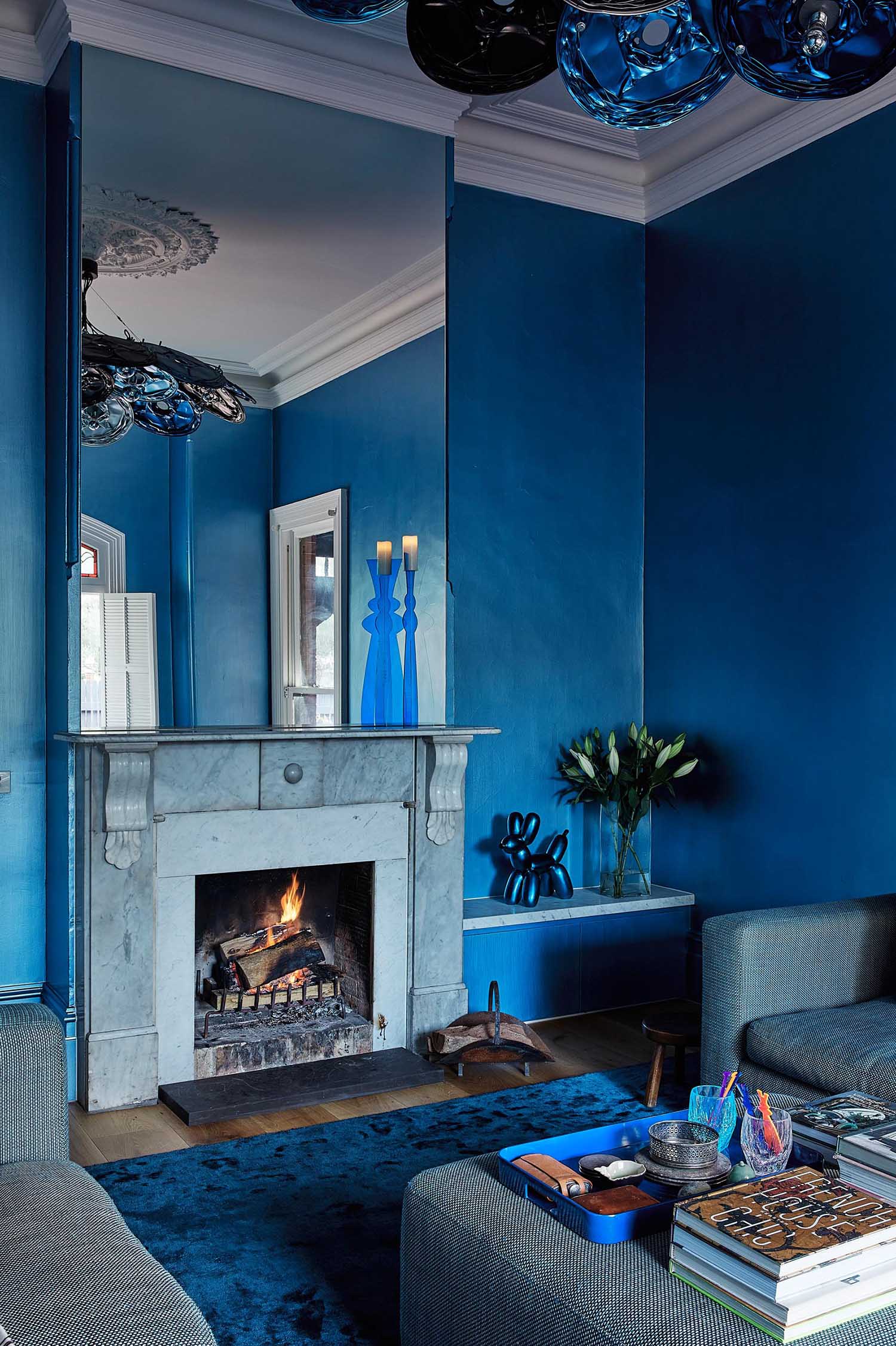 An updated living room in a heritage house has a bold blue color palette.
