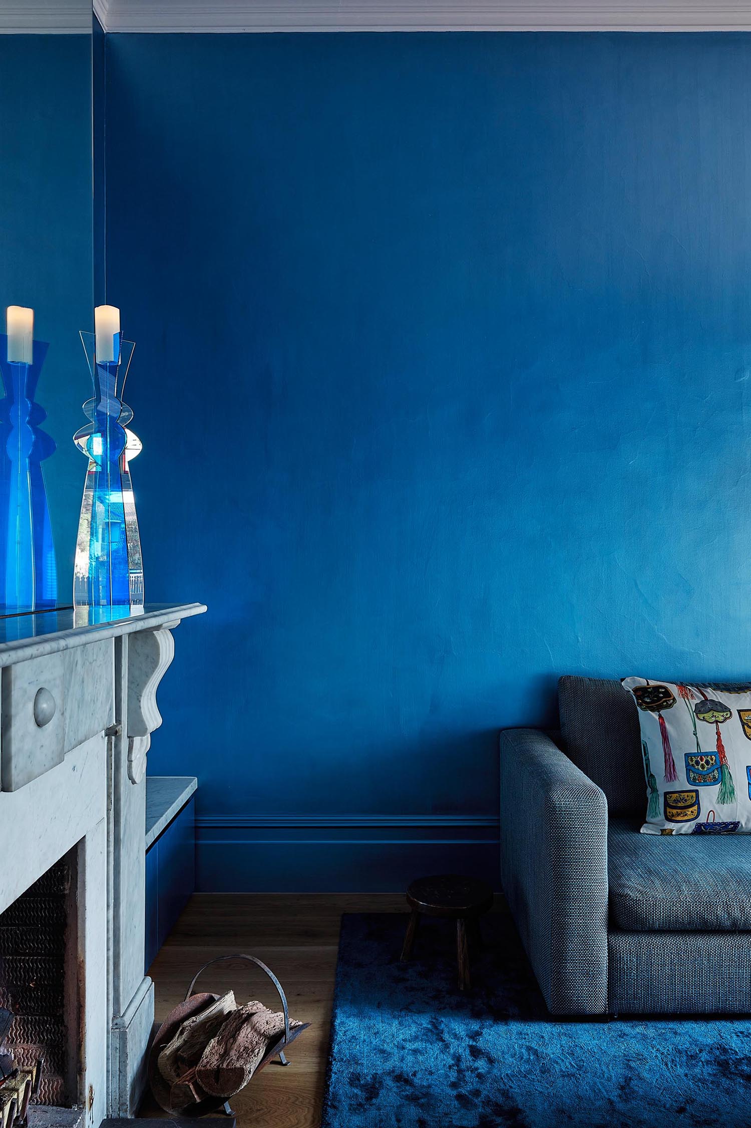 An updated living room in a heritage house has a bold blue color palette.