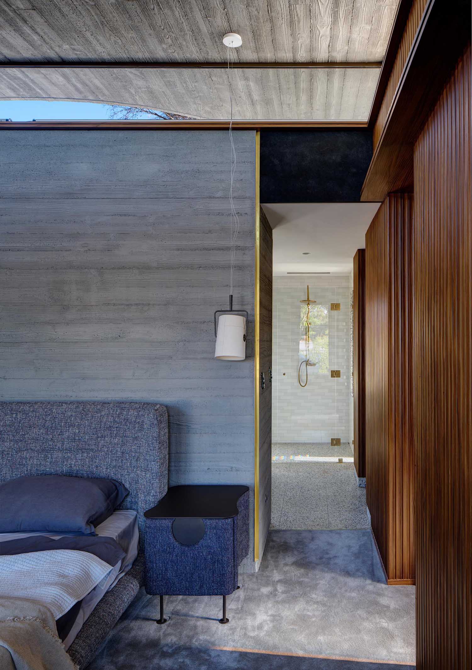 A modern bedroom with board formed concrete walls.