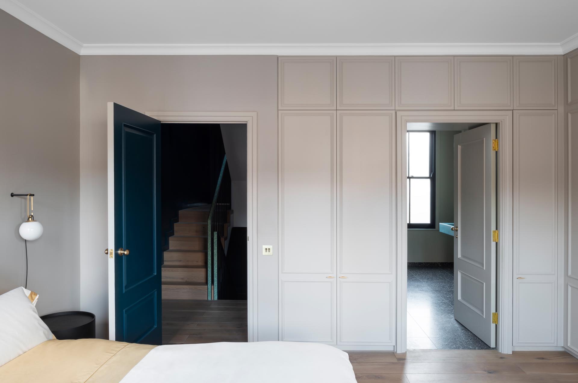 A modern bedroom with built-in closets that math the walls.