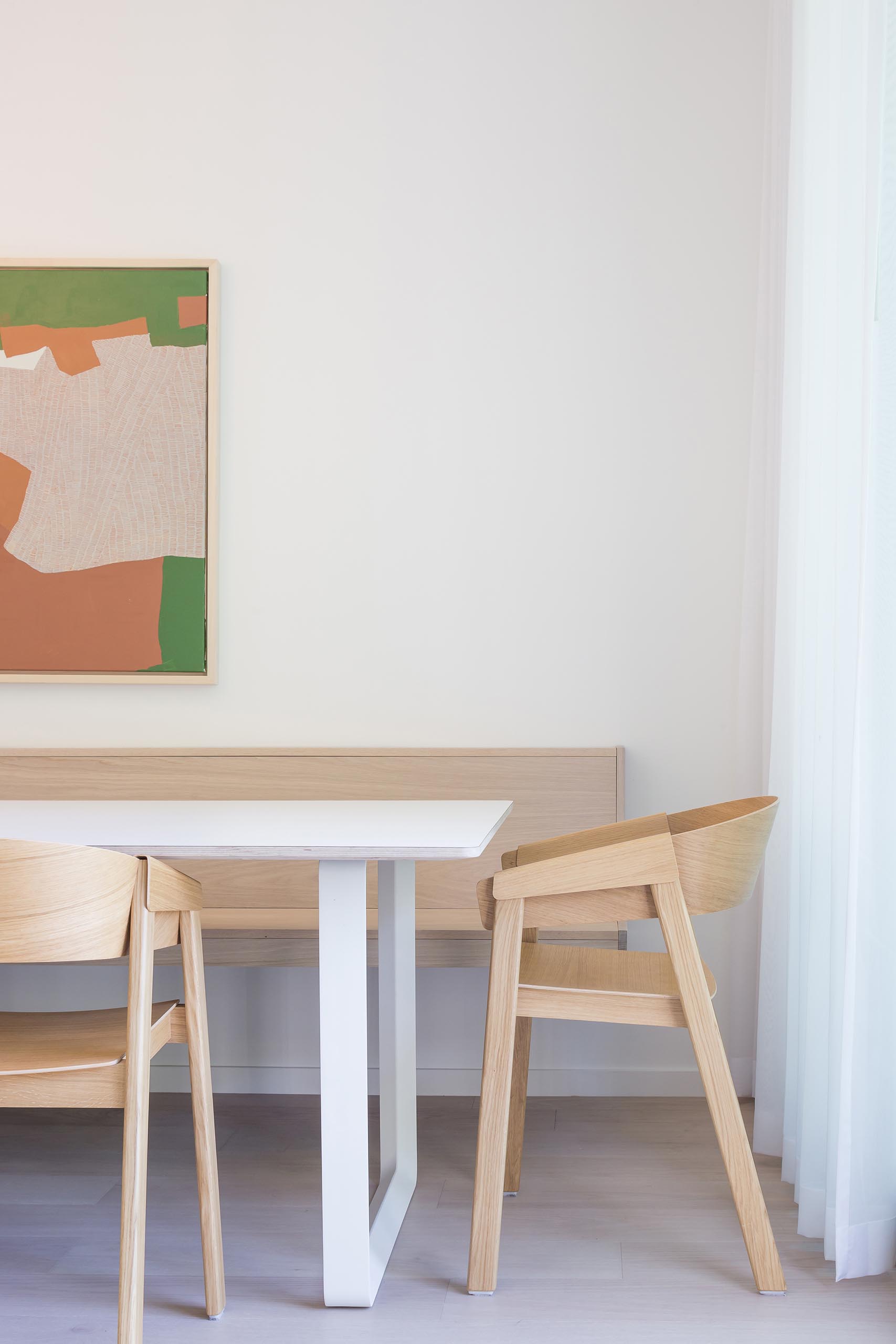 This modern dining area includes a built-in banquet bench that runs along the wall.