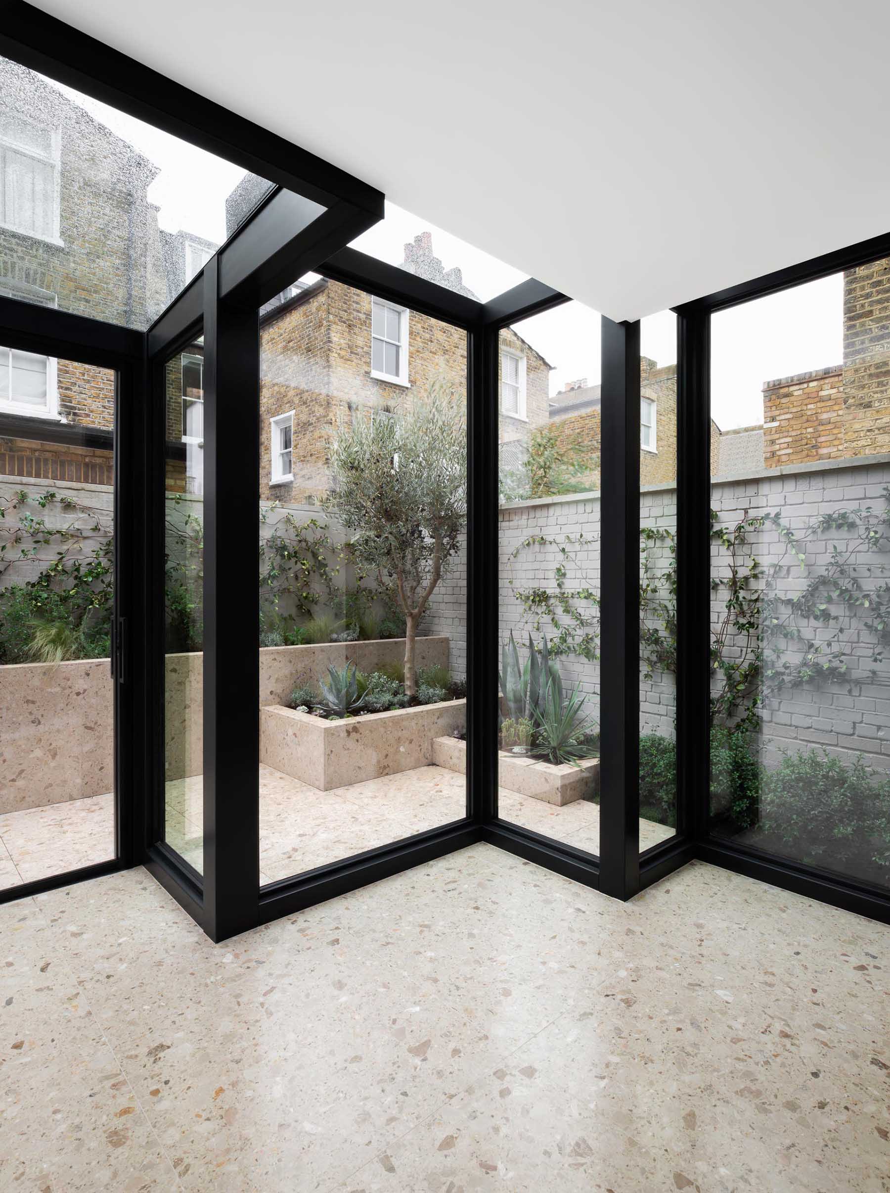 A modern house extension with thick black steel window frames.