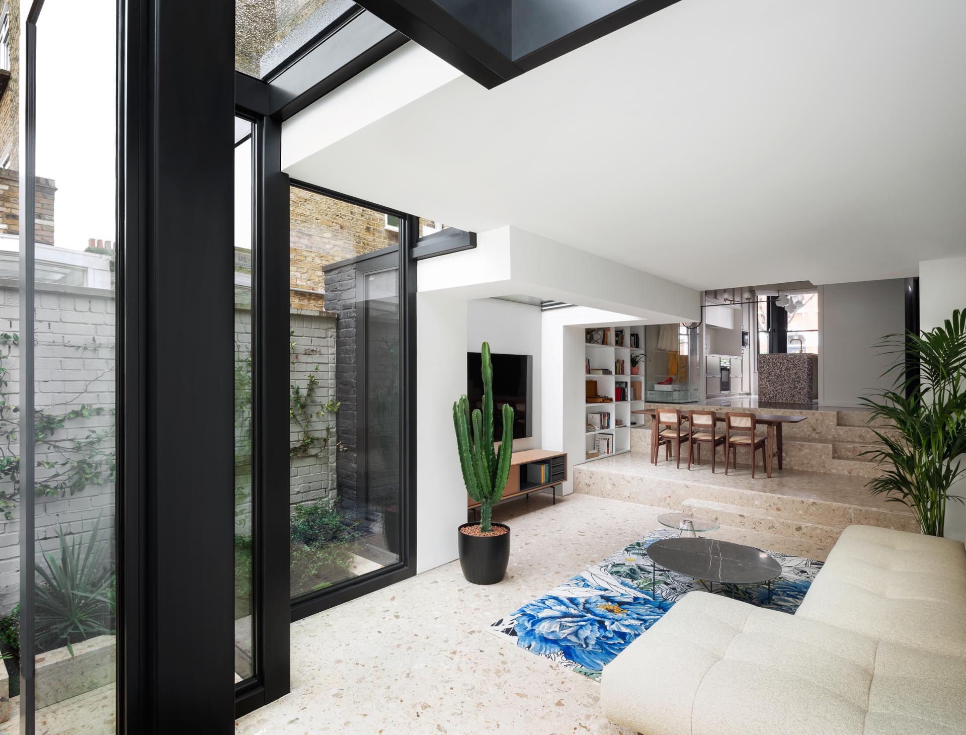 A modern house extension with Terrazzo flooring and thick black steel window frames.