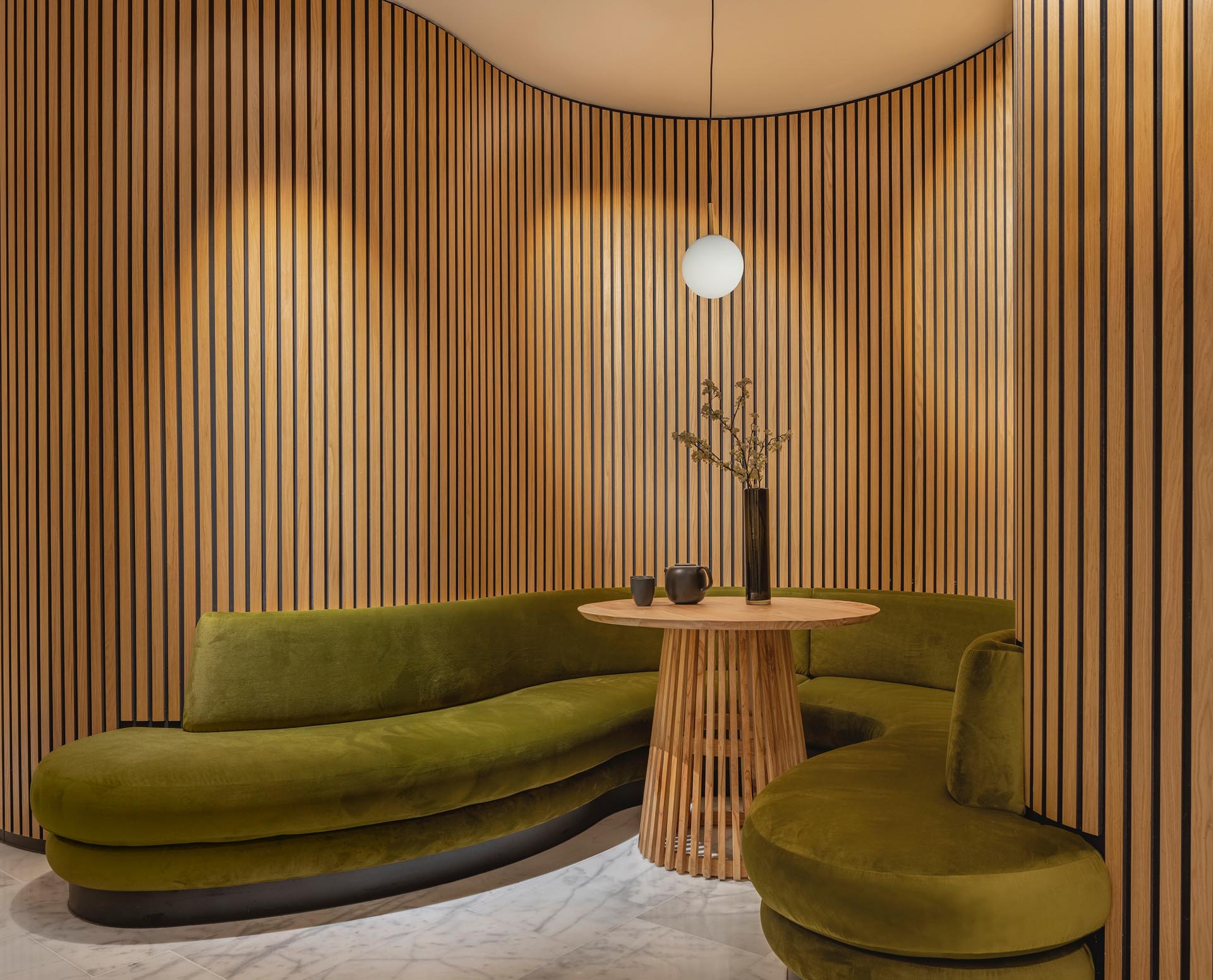 A modern massage boutique with curved wood walls and benches that create a sense of calm and relaxing.