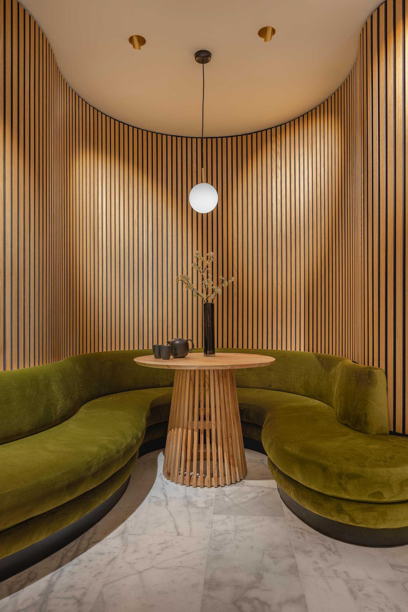 A modern massage boutique with curved wood walls and benches that create a sense of calm and relaxing.