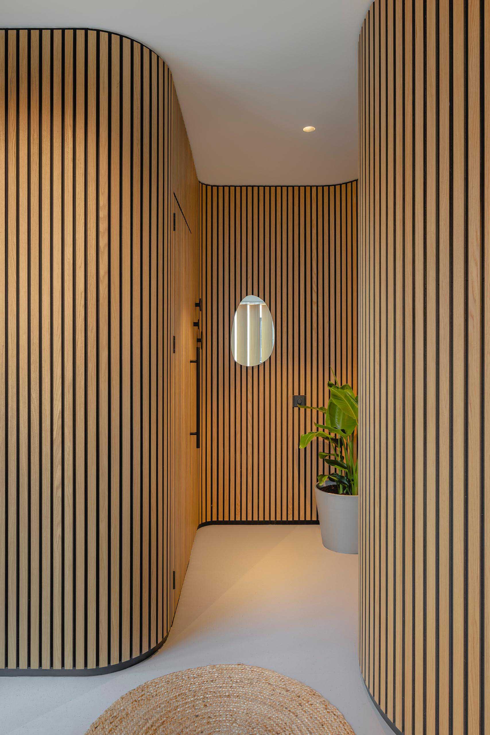 Blending into the organically shaped walls are the doors to the massage rooms, only noticeable by the black hardware.