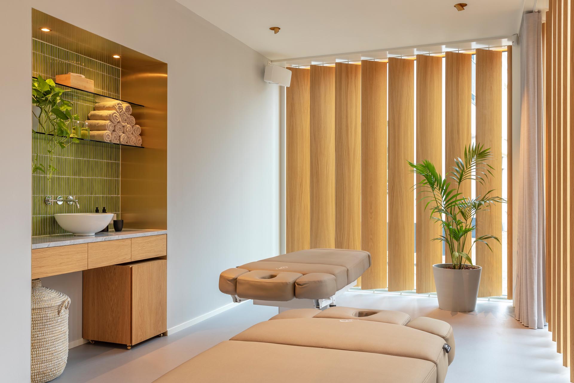 These private treatment rooms in a massage boutique feature floor-to-ceiling, pivoting oak lamellas that gently block the views from passers-by when they are closed. 