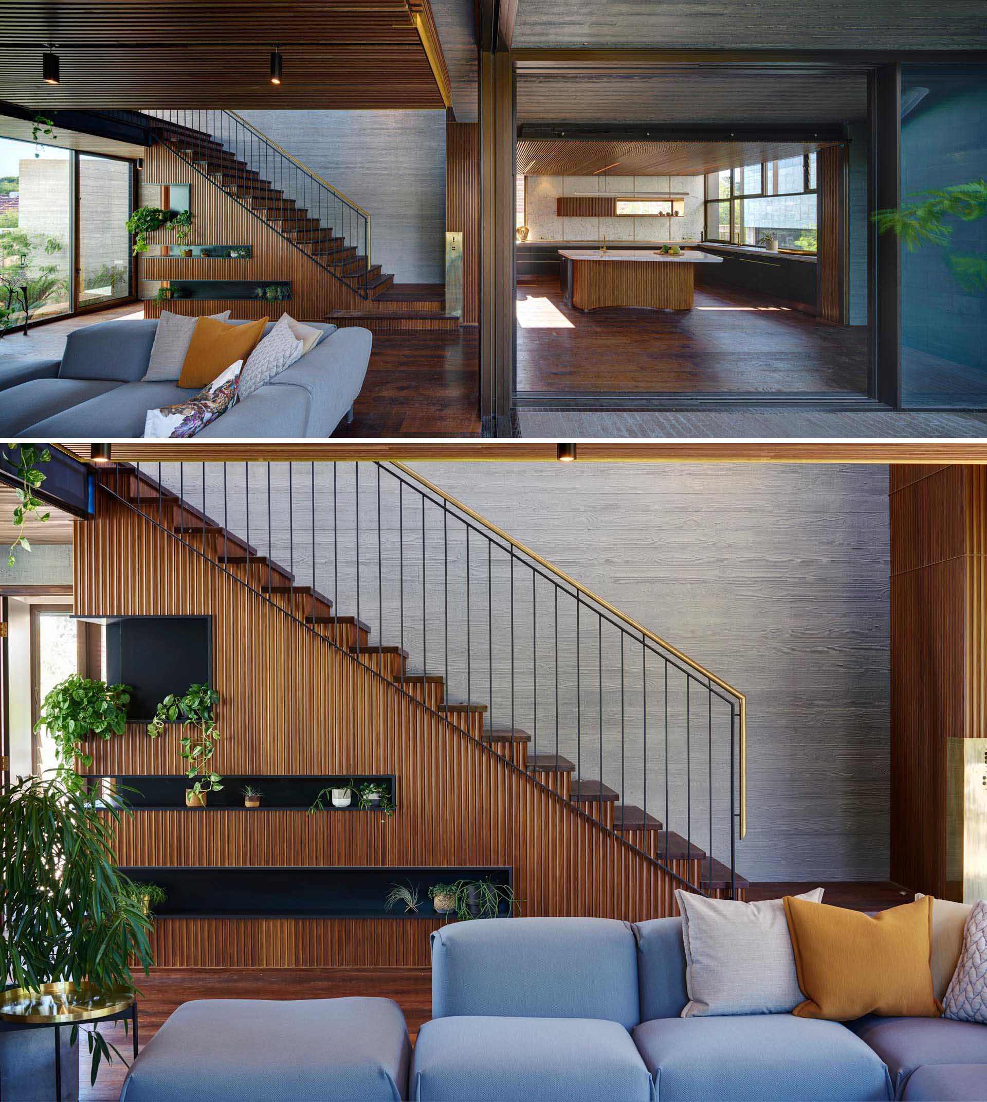 A modern home with wood stairs that showcase a brass handrail and board formed concrete walls.