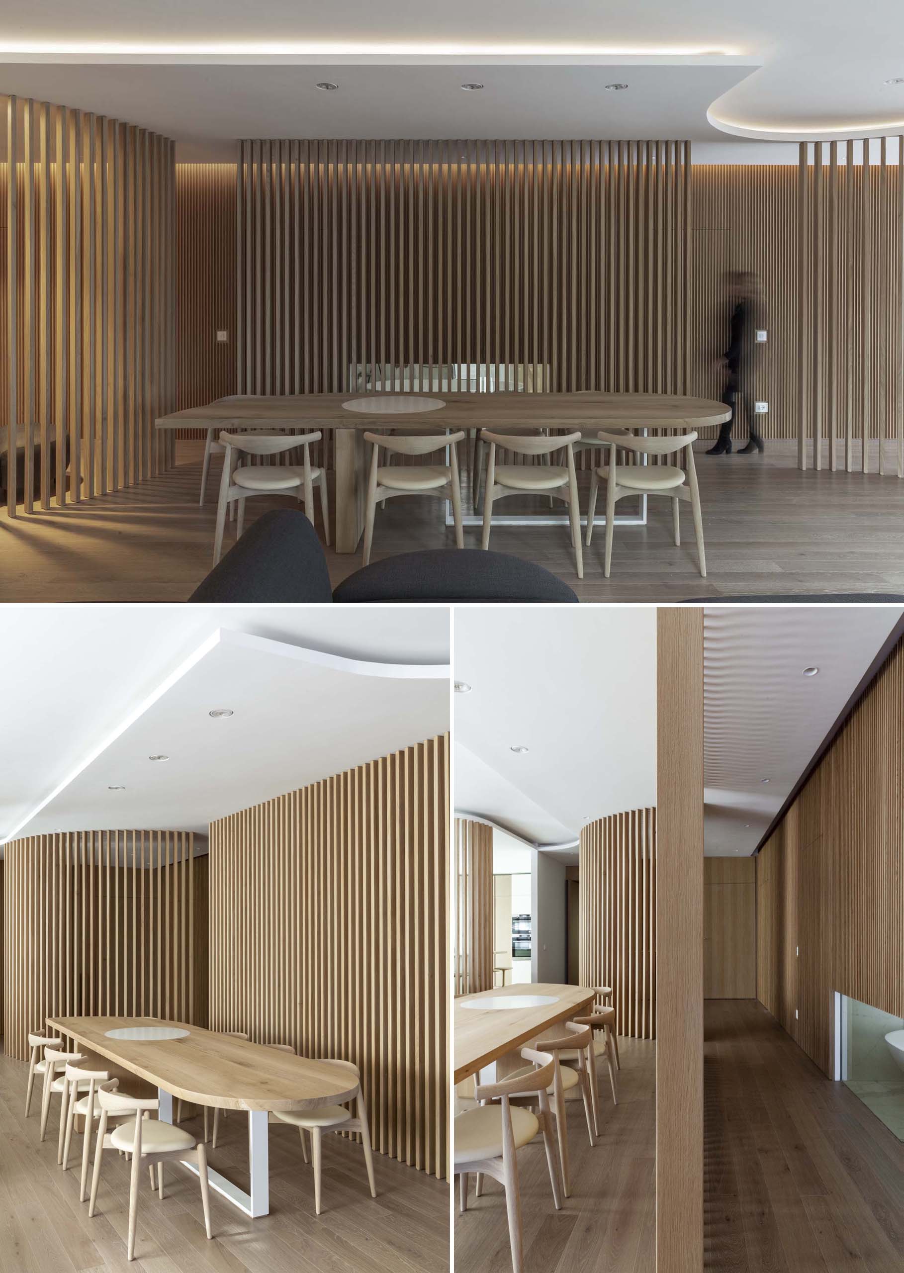 An open modern dining area has a backdrop of vertical oak wood slats.
