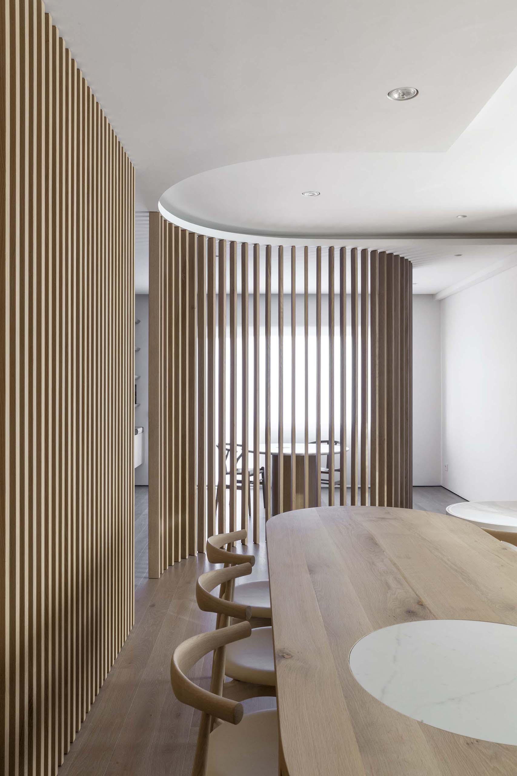 Curved oak partitions separate various zones of the interior in this apartment.