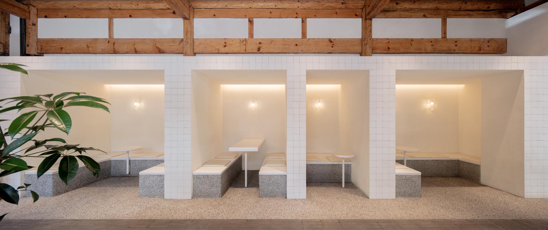 White tiles have been used to create a clean and minimalist look for the seating in this modern coffee shop.