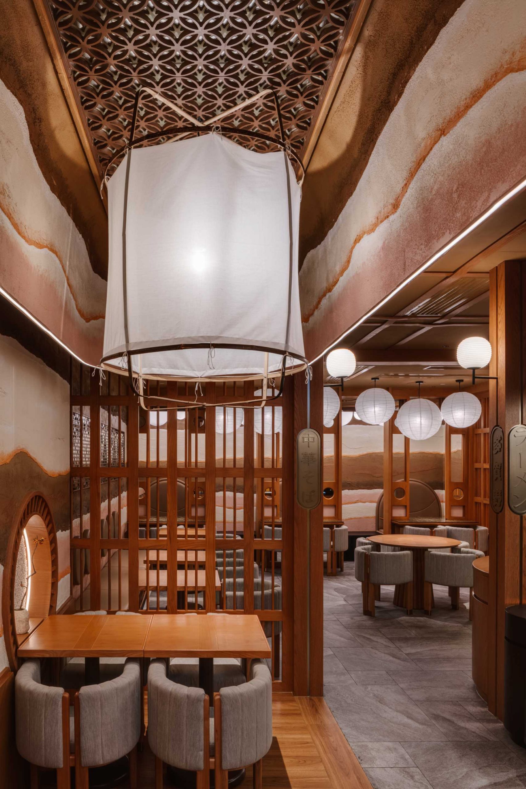 Above some of the tables in this modern restaurant are natural pendant lights made of bamboo and paper by Ay illuminate. Various sizes of Noguchi sphere lanterns are also present in the interior.