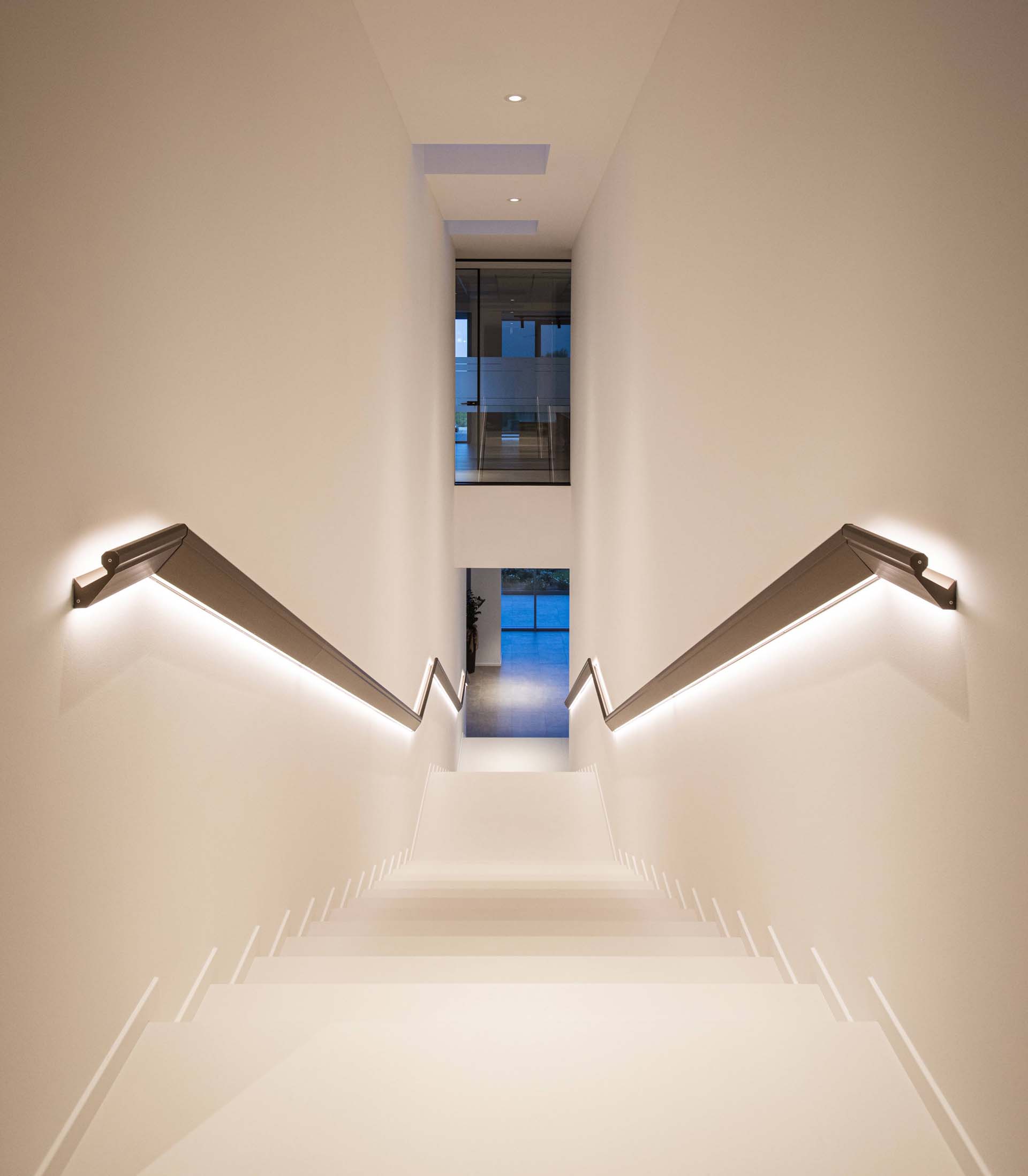 A modern stair handrail with hidden lighting.
