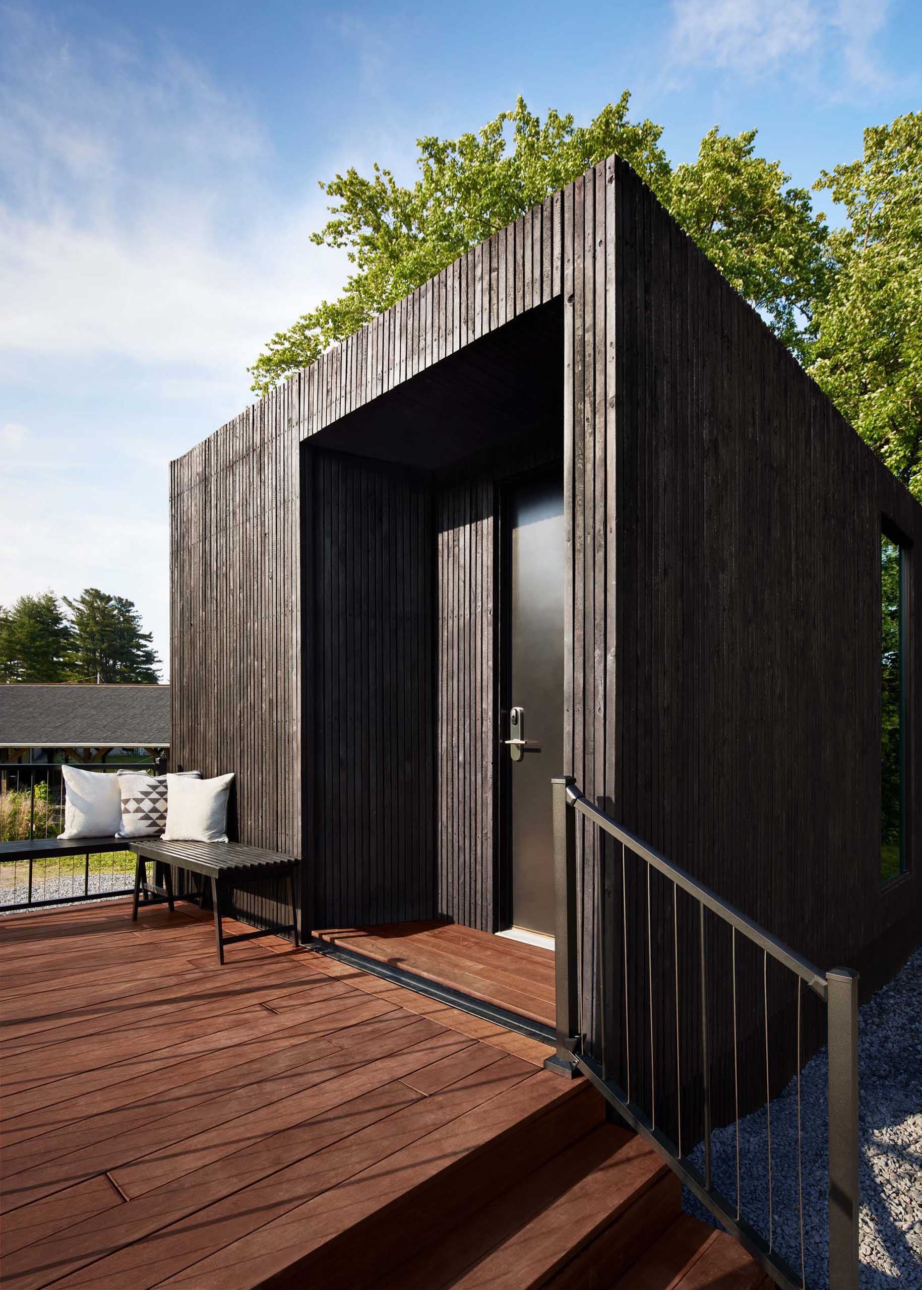 A modern wood-clad prefabricated hotel room with a 120 square foot outdoor deck.