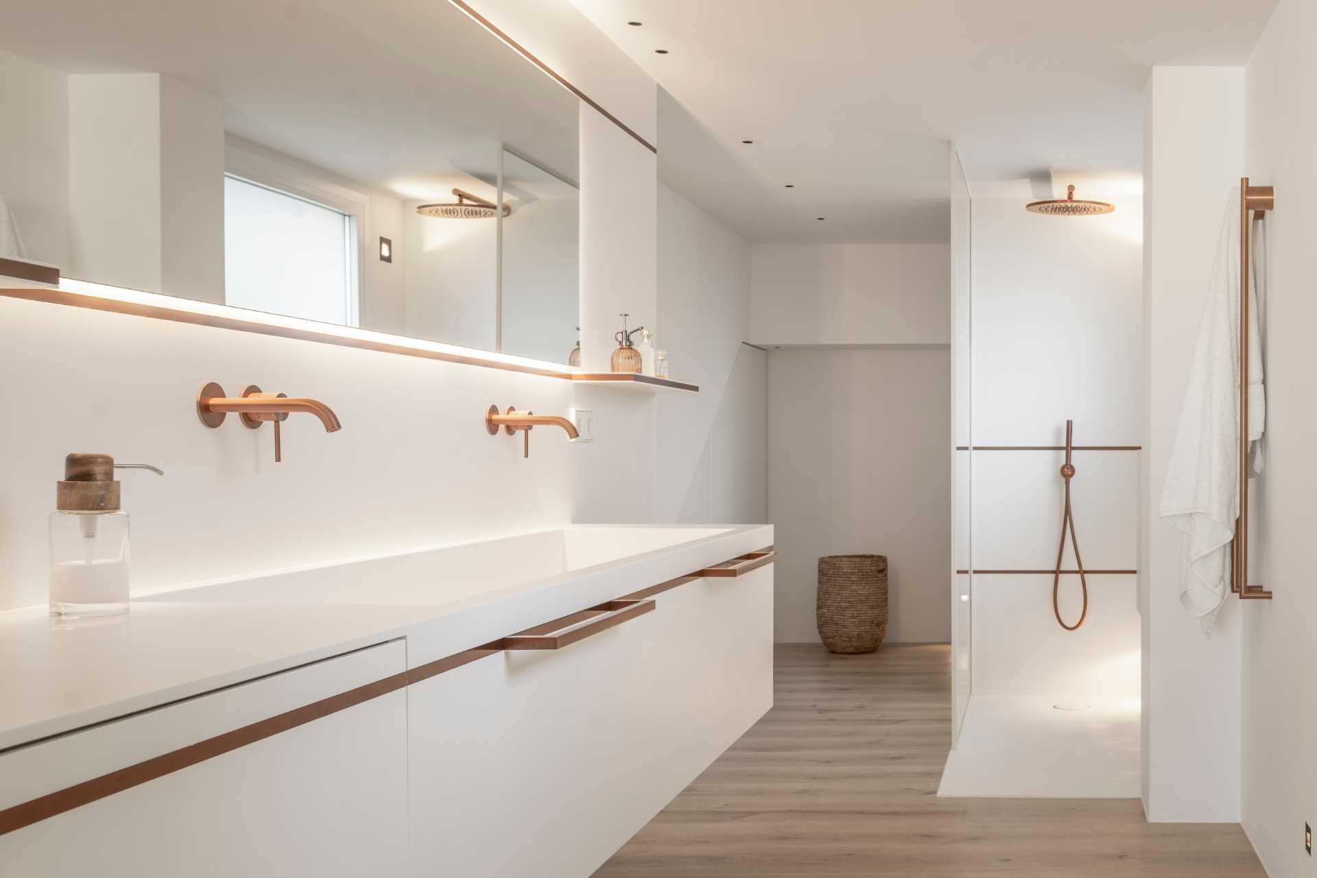 White, the designer’s hallmark, was chosen as the main hue for this spacious bathroom as it balances the copper accents throughout, like in the hardware, shelving, and faucets.