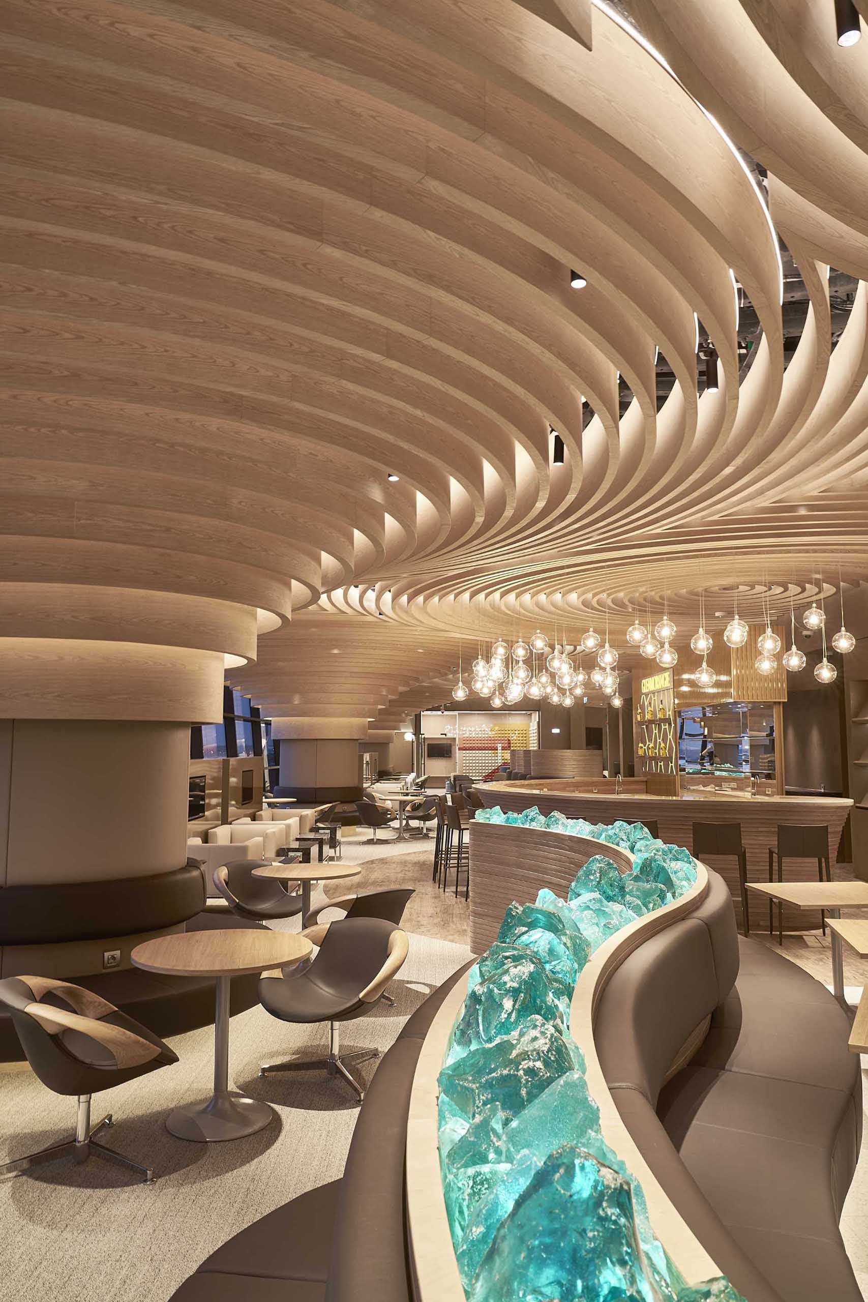 Geometric forms made from curved wood cover the ceiling of this airport lounge.