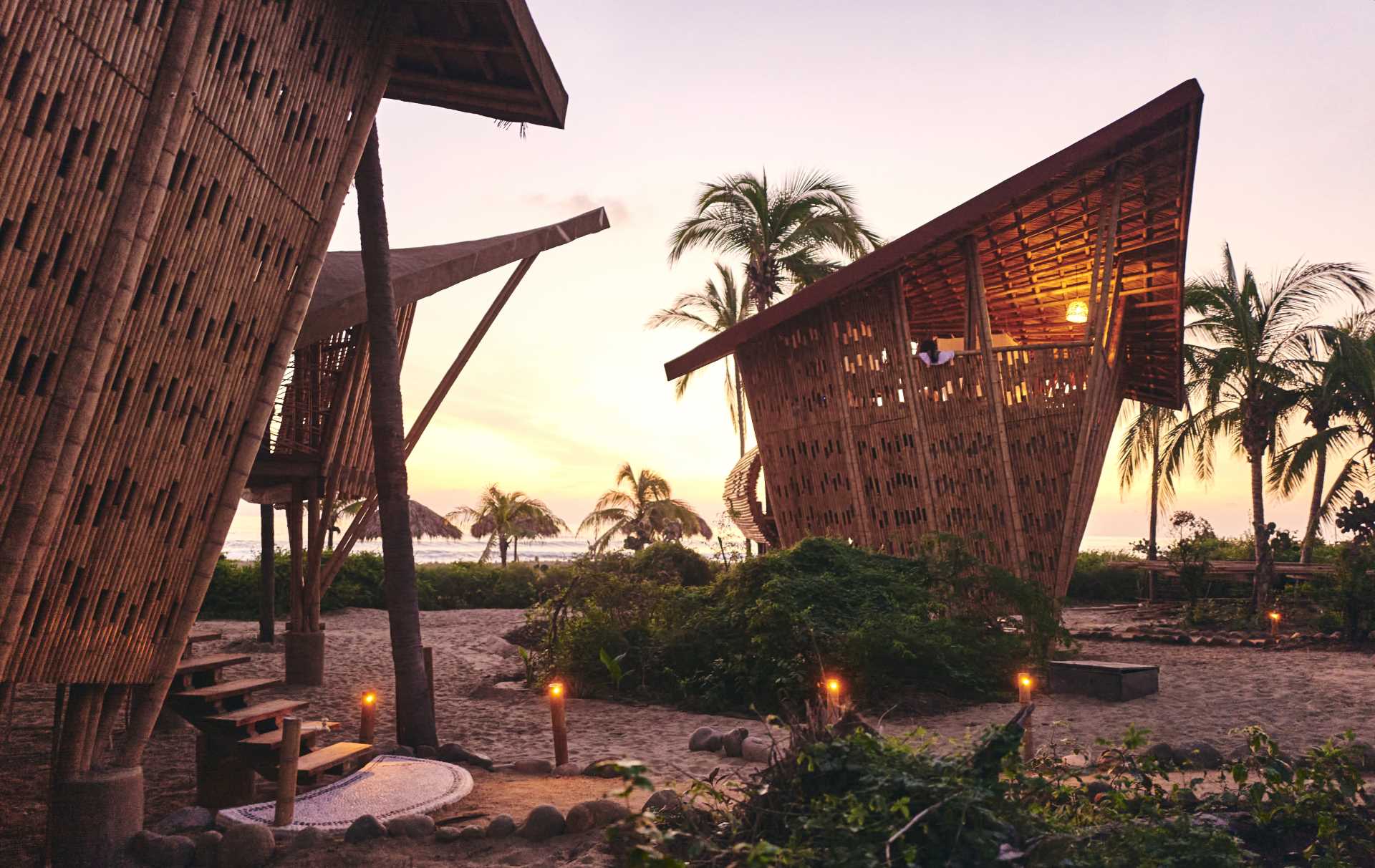 The bamboo structure of these tree houses are highlighted at night by the warm glow of the lighting.