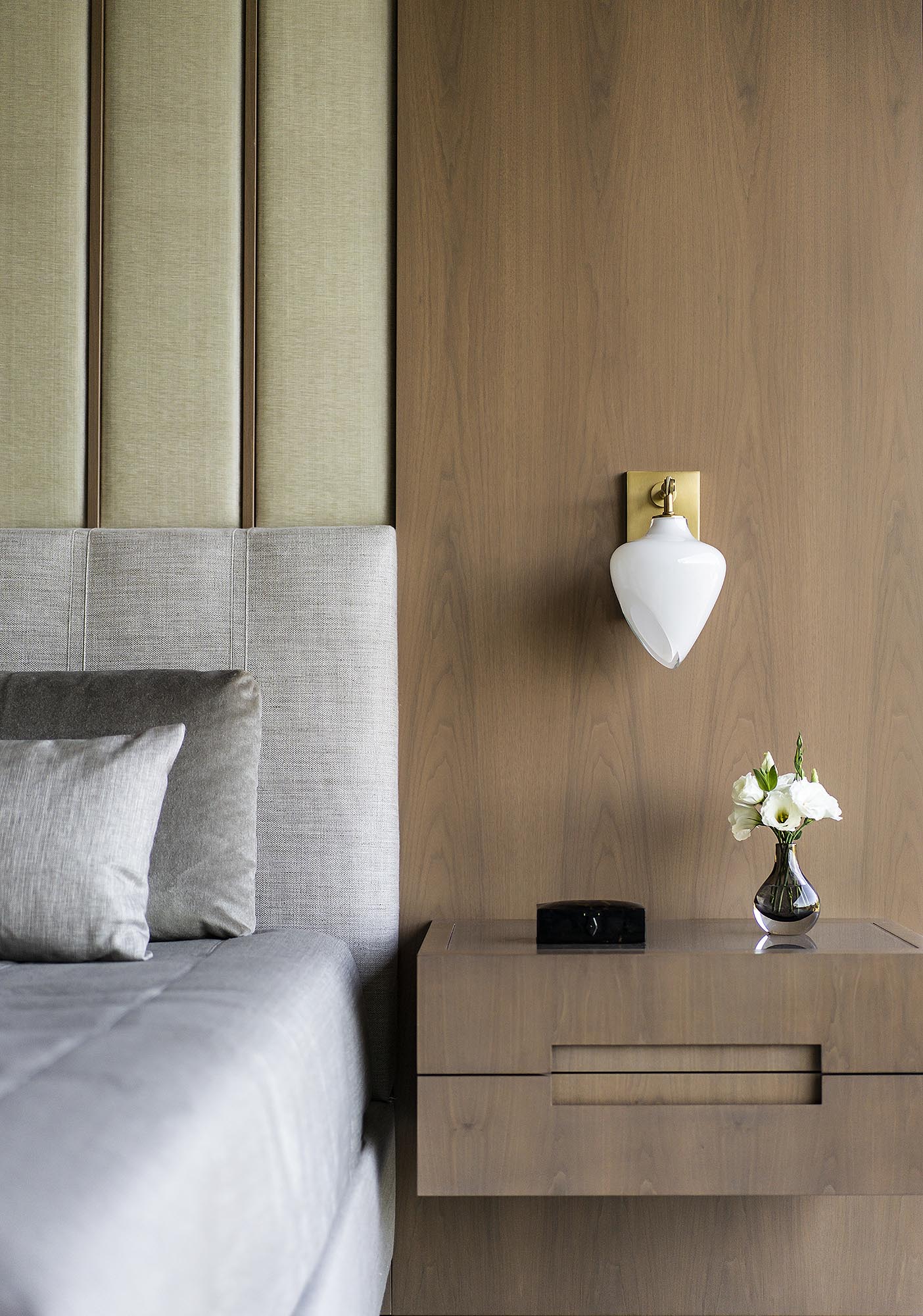 A modern bedroom with an accent wall made from wood and upholstered panels.