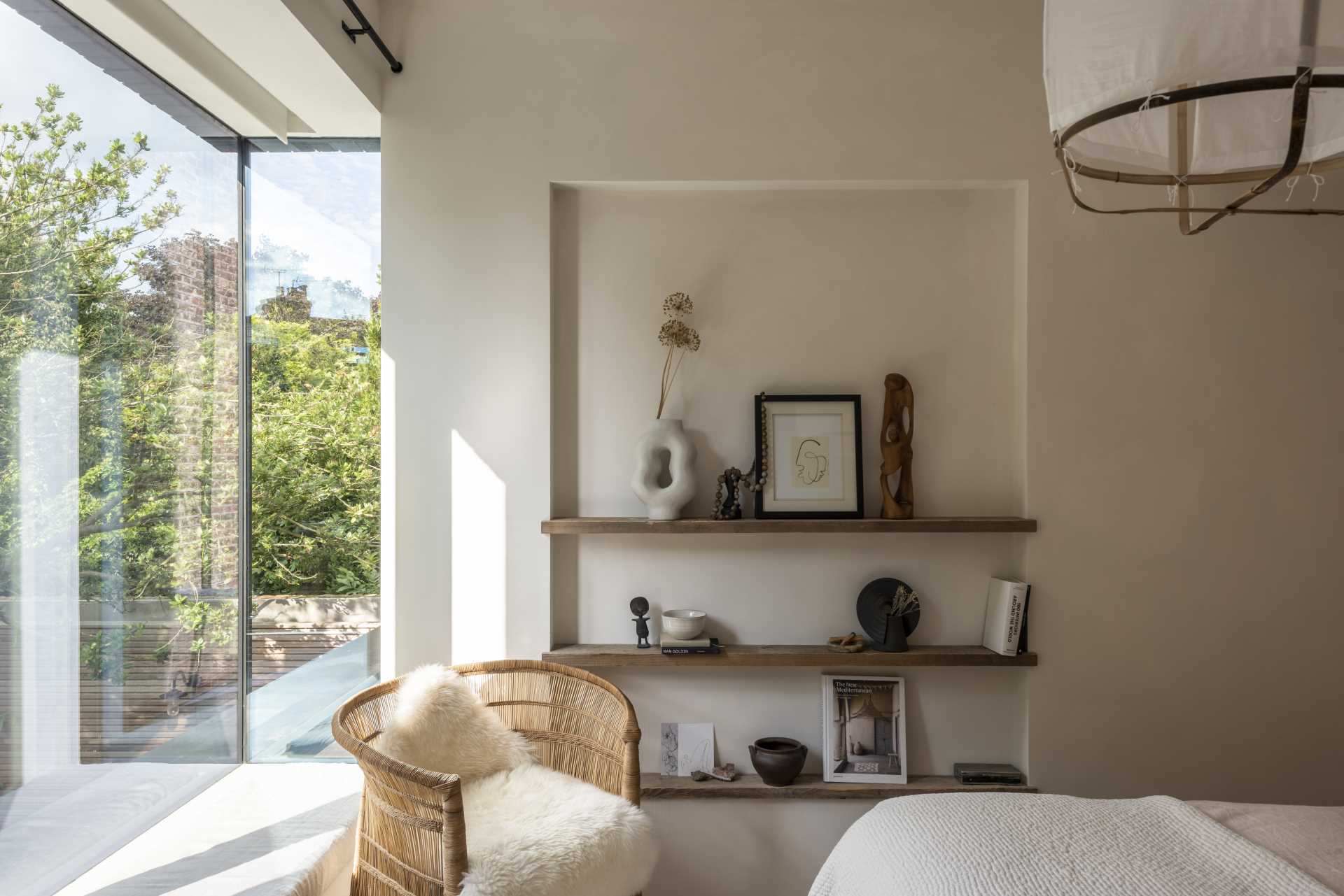 The large floor-to-ceiling windows provide this modern bedroom with a view of the garden.
