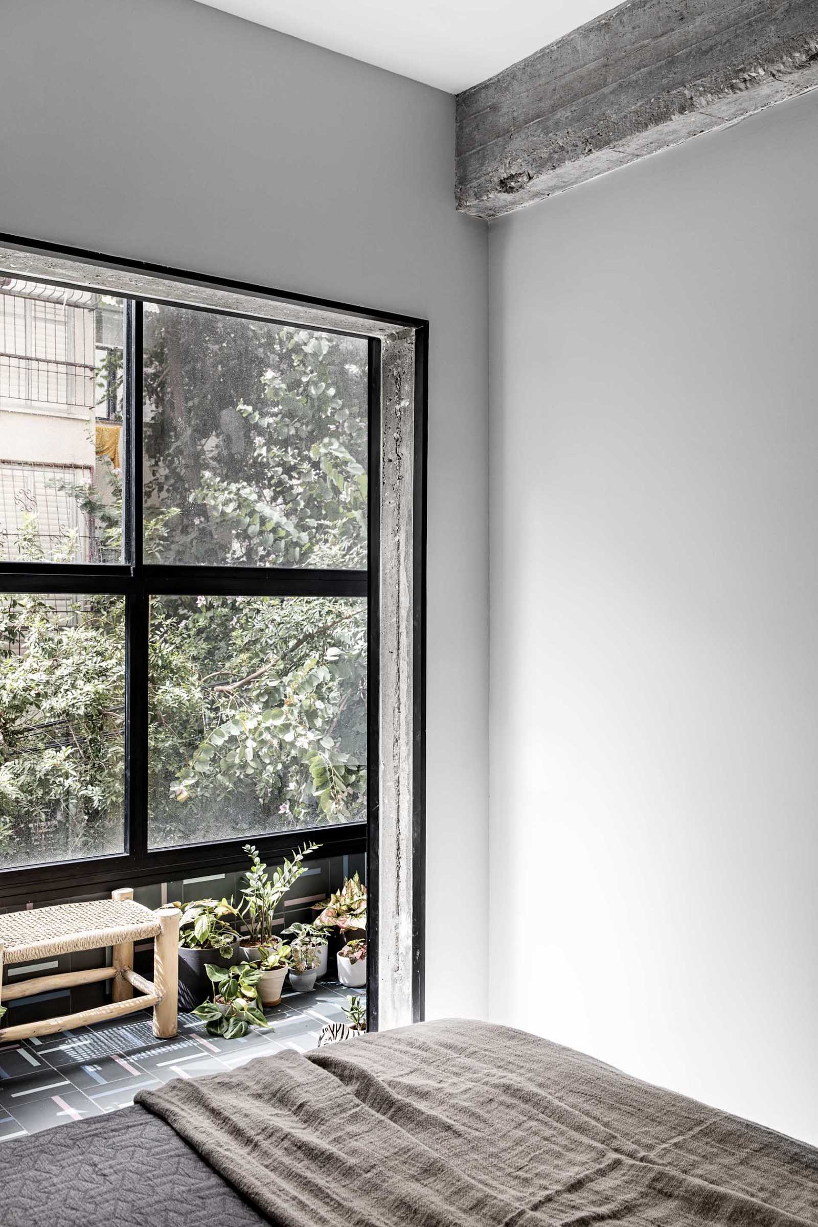 A modern bedroom with black window frames.