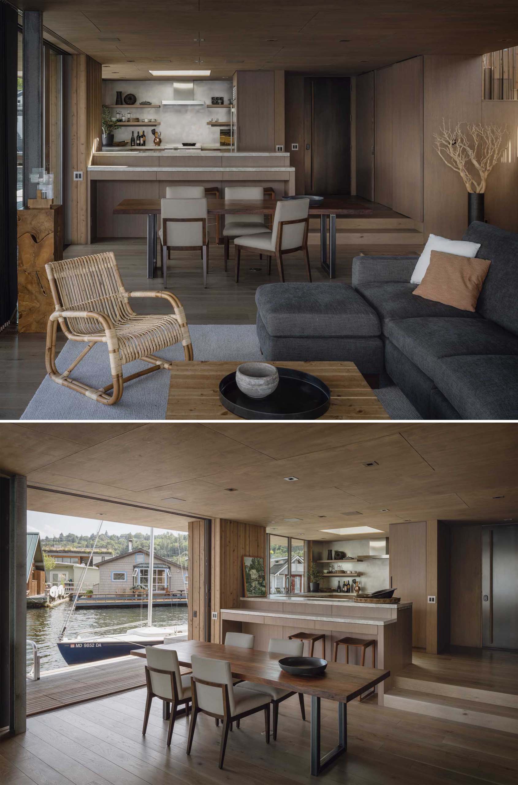 Separating the living room and the kitchen of this modern floathome, is the open plan dining area with a wood dining table that features metal legs.